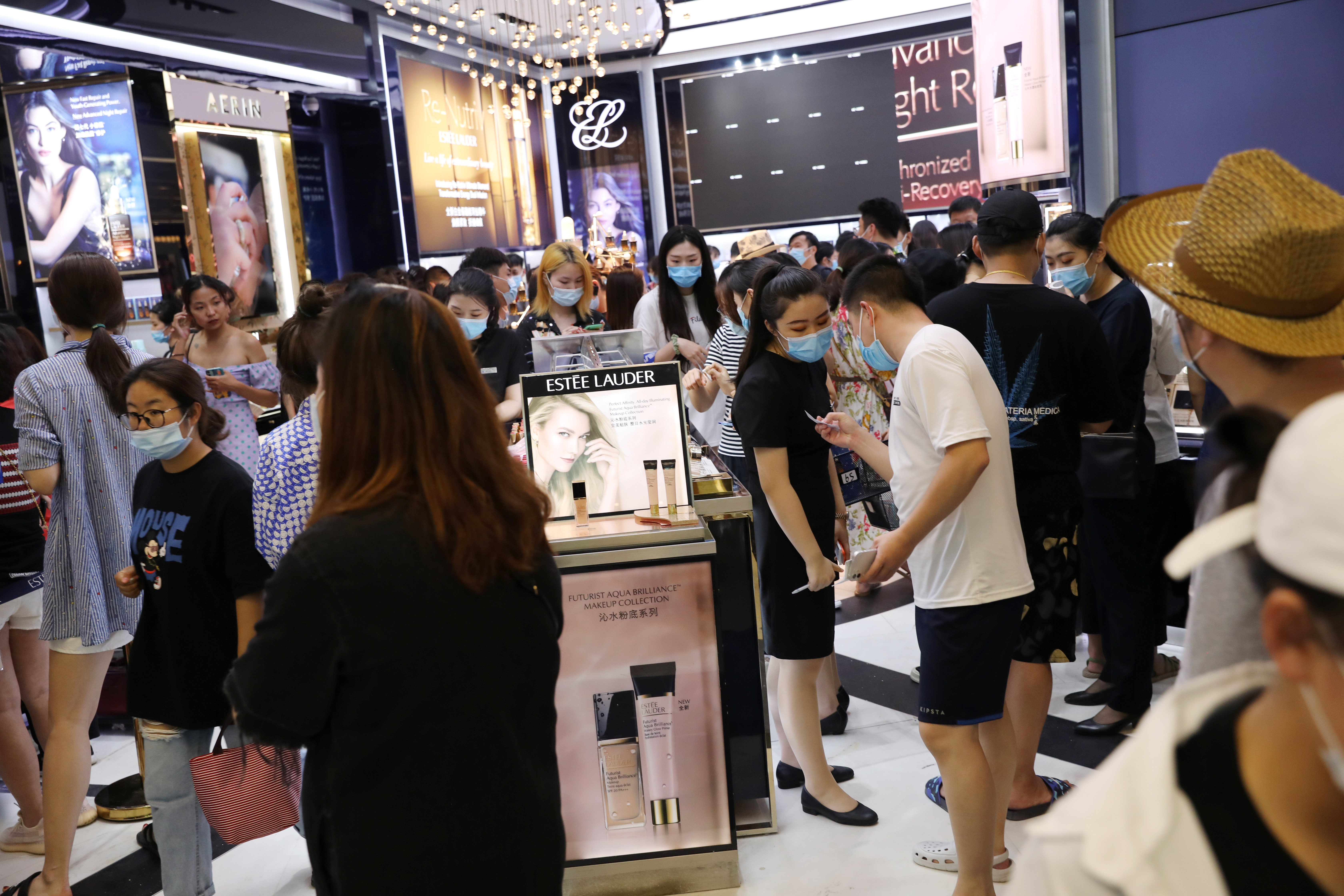 People shop at a cosmetics store inside the Sanya International Duty-Free Shopping Complex in Sanya