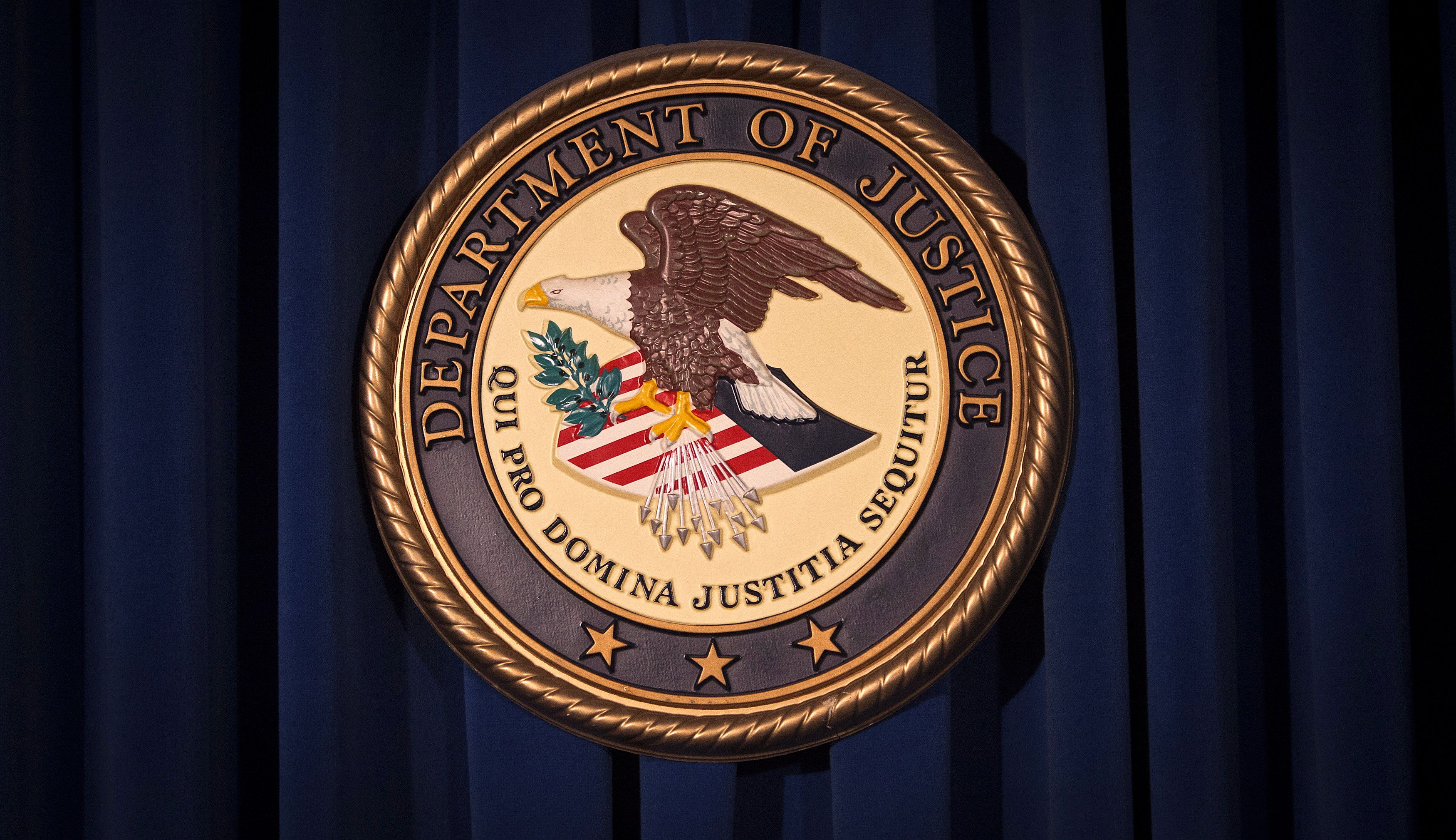 The Department of Justice (DOJ) logo is pictured on a wall after a news conference in New York December 5, 2013./File Photo
