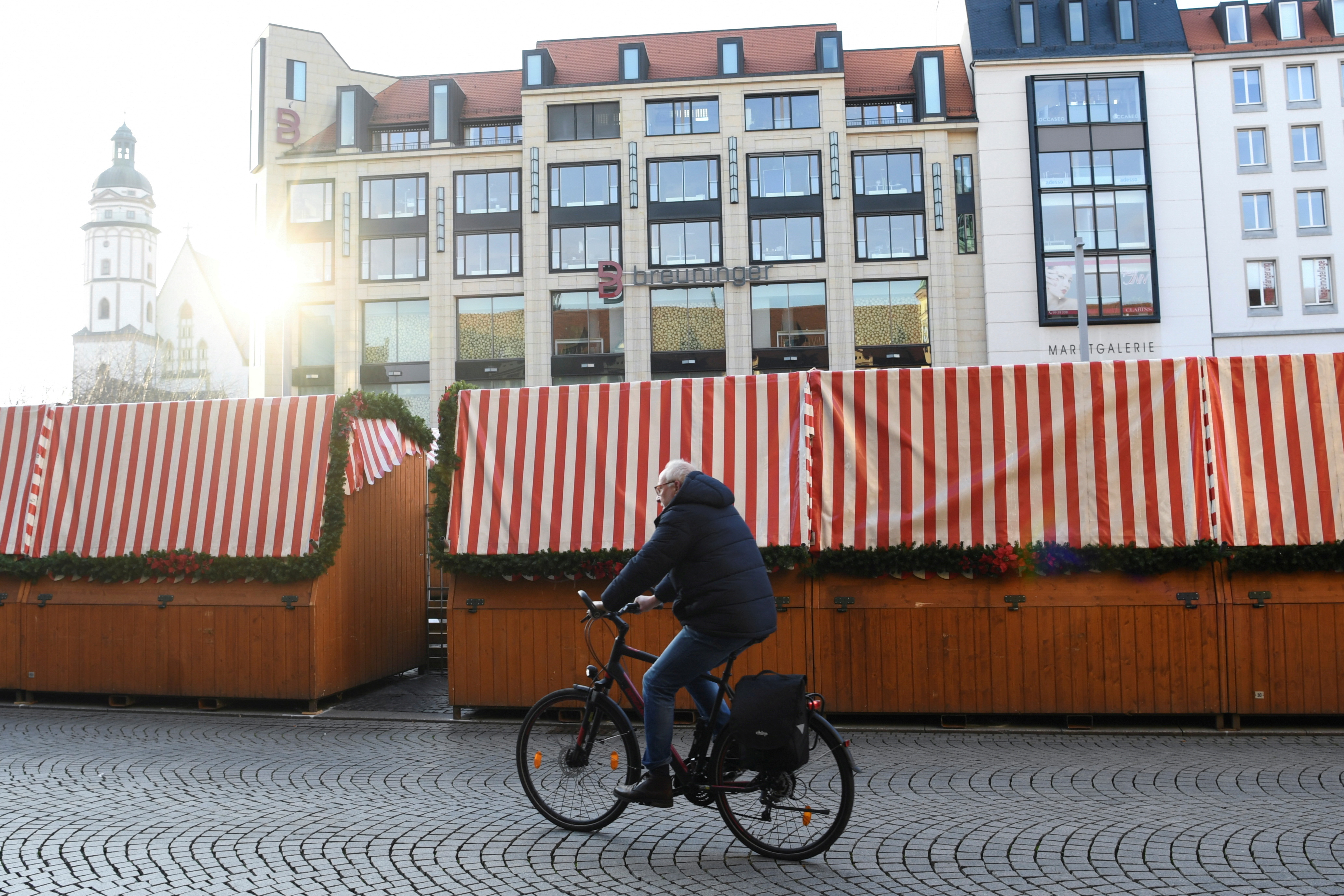 A man rides his bicycle past closed Christmas stands at the market square, amid the coronavirus disease (COVID-19) pandemic, in Leipzig, Germany, November 28, 2021. REUTERS/Annegret Hilse