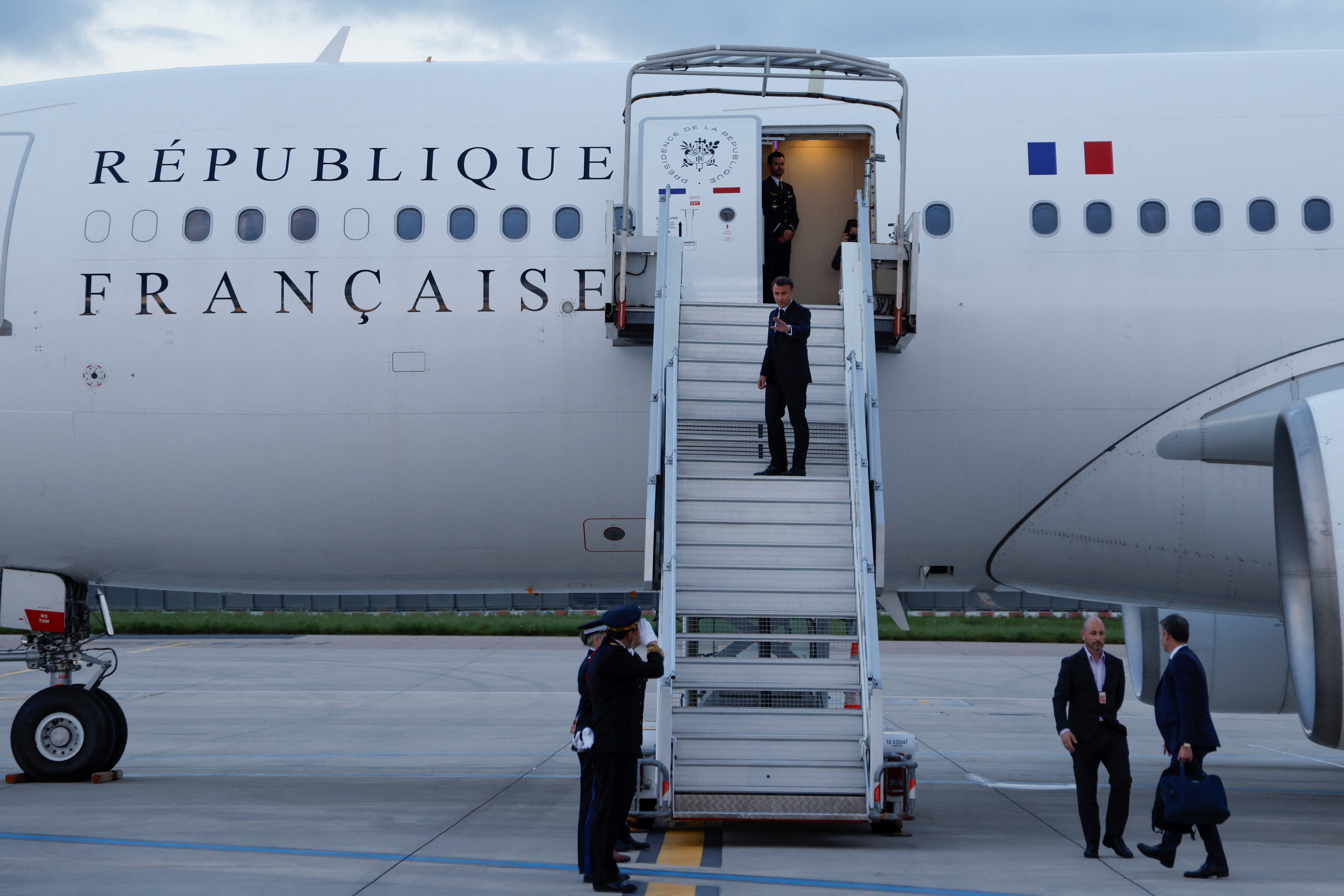 France's President Emmanuel Macron waves as he boards his Presidential plane to travel to the Pacific archipelago of New Caledonia