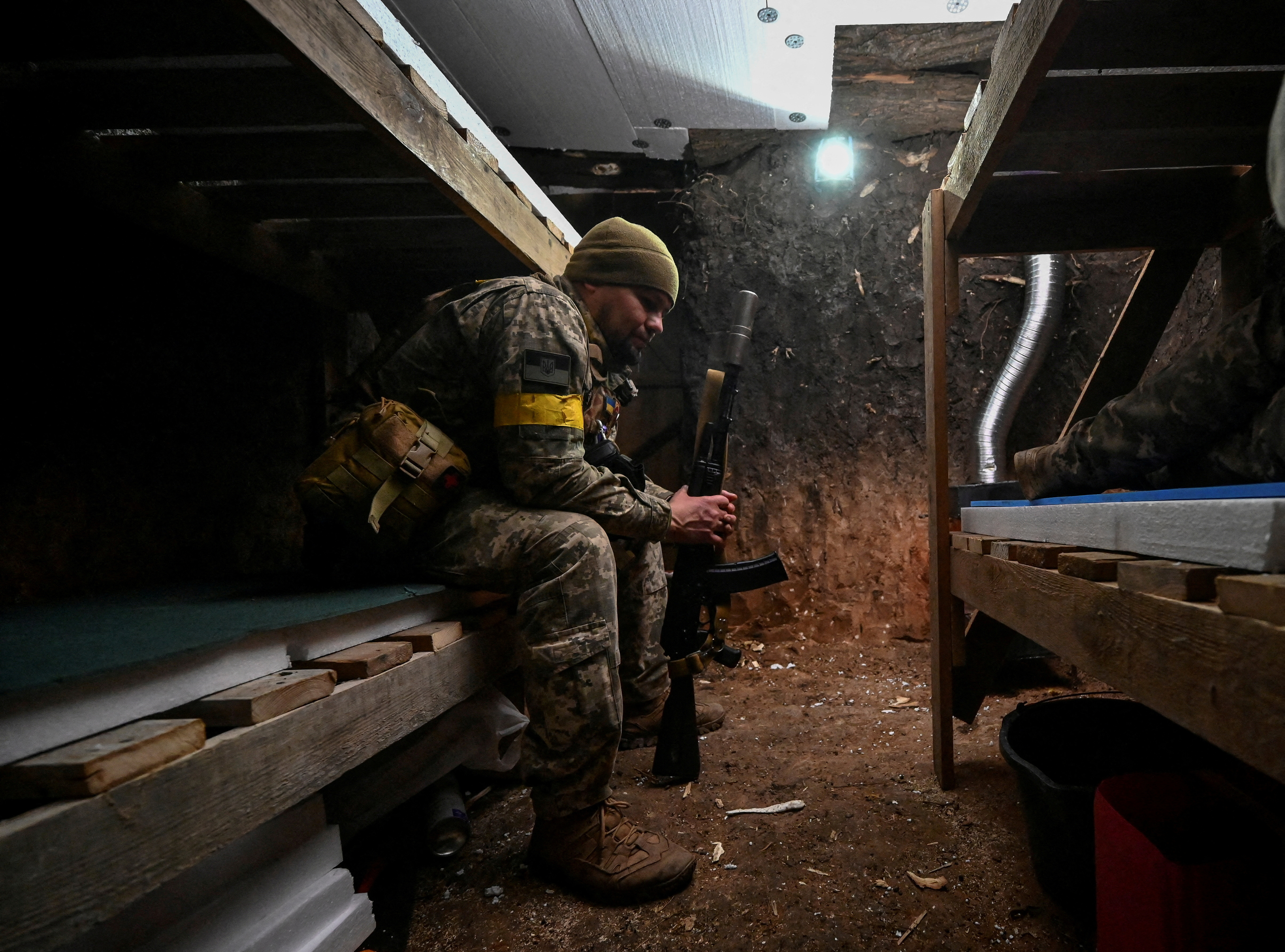 A serviceman rests in a dugout at his position on a front line in Zaporizhzhia region