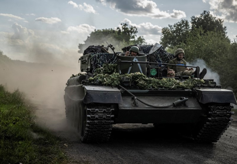 Ukrainian servicemen ride a military vehicle near the Russian border in Sumy region