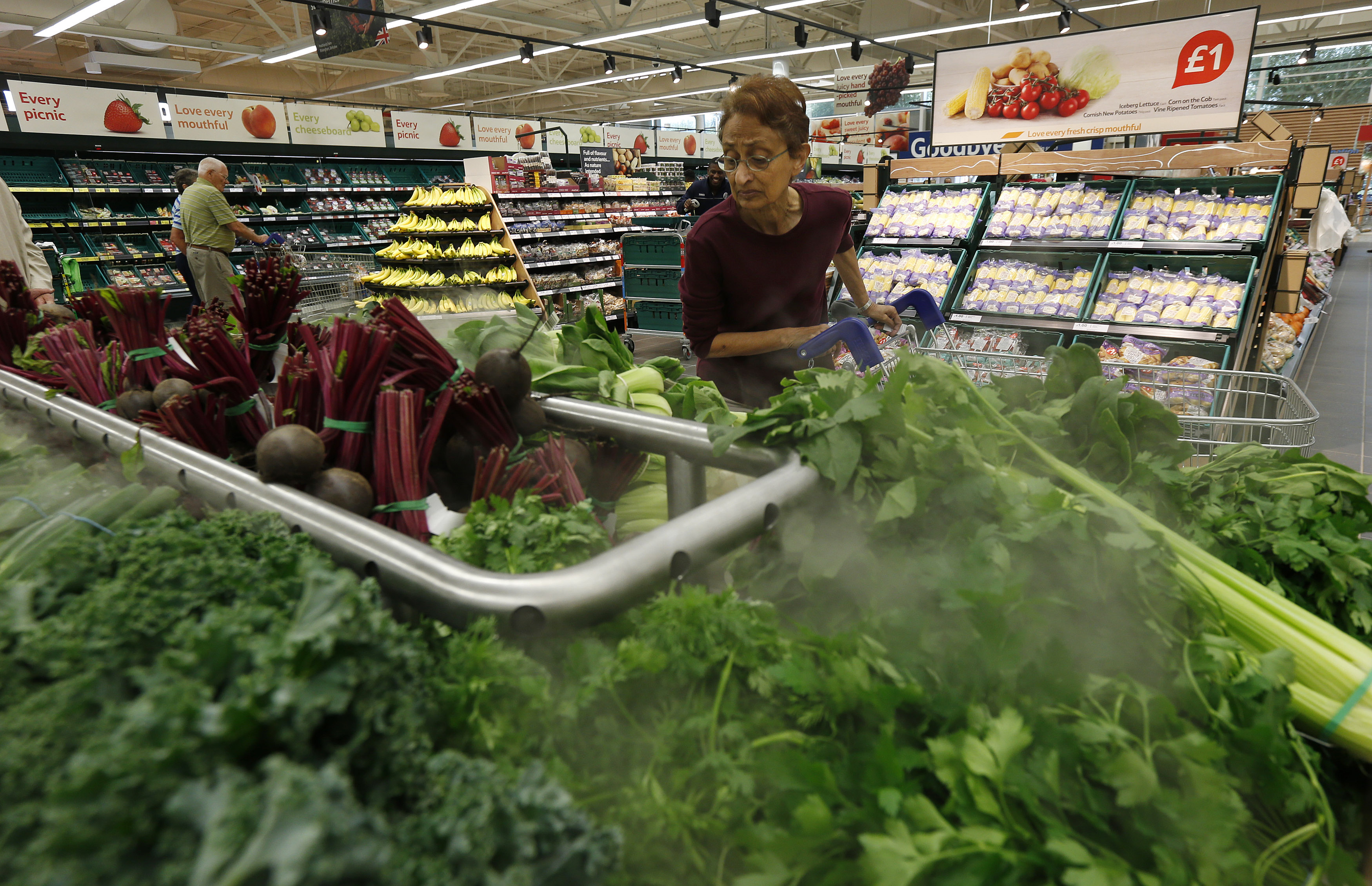 A customer shops for vegetables at a Tesco Extra supermarket in Watford, north of London