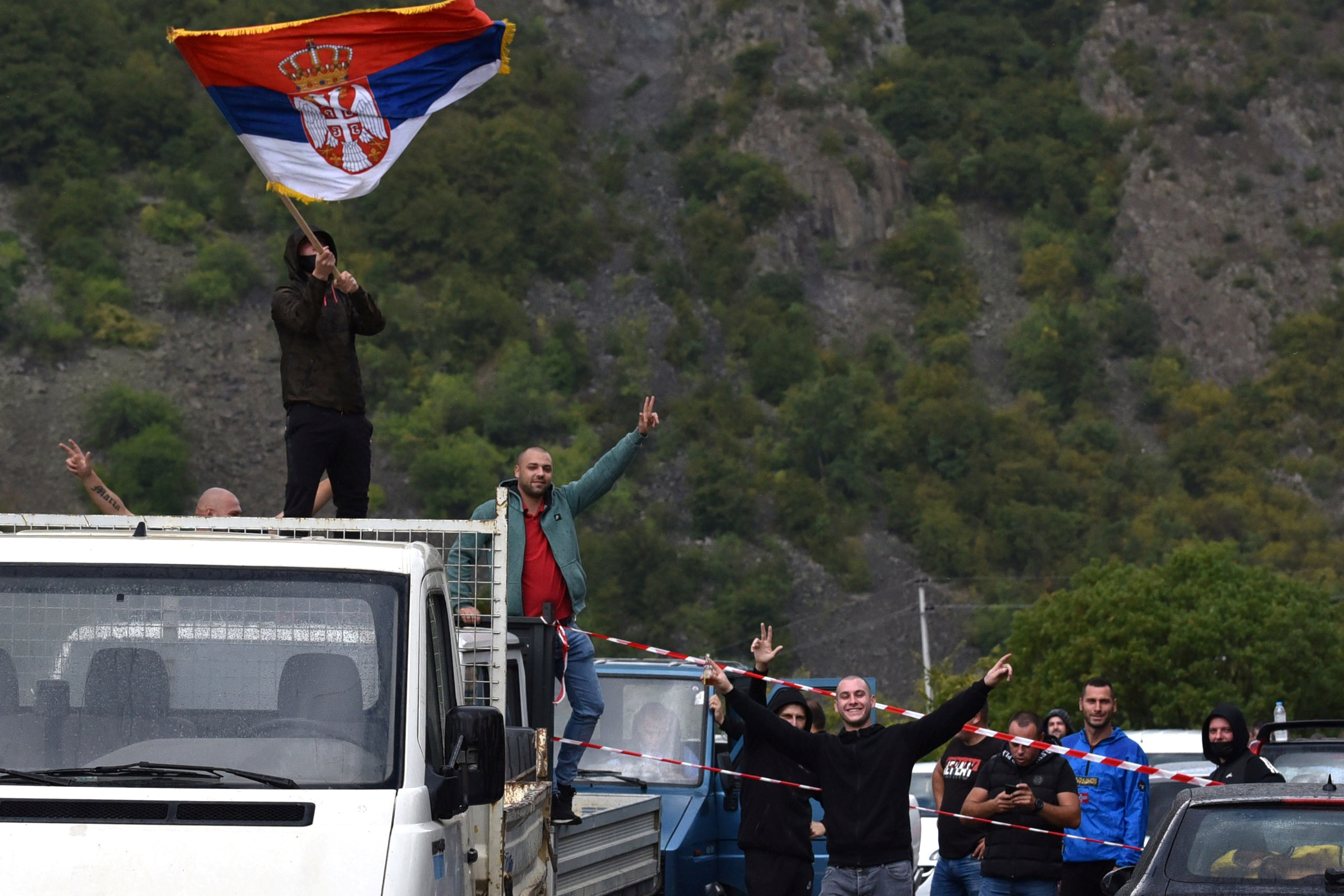 A Kosovo Serb is pictured waving a Serbian flag as people protest against a government ban on entry of vehicles with Serbian registration plates in Jarinje