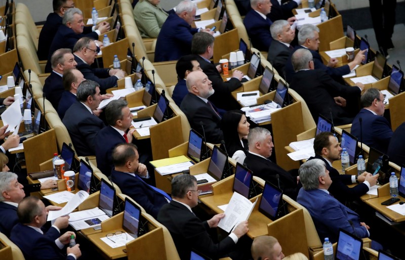 Members of Russia's lower house of parliament attend a session to consider constitutional changes in Moscow