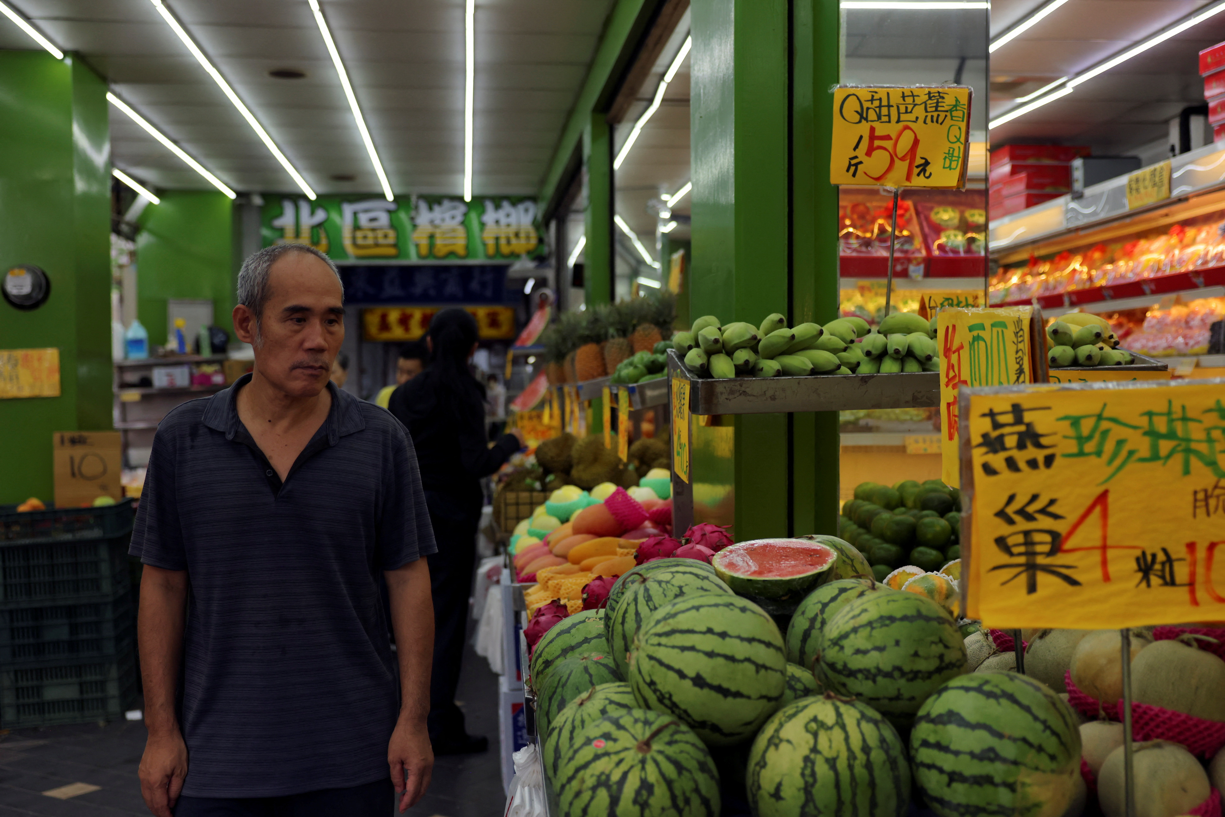 Man walks past a fruits shop in Taipei