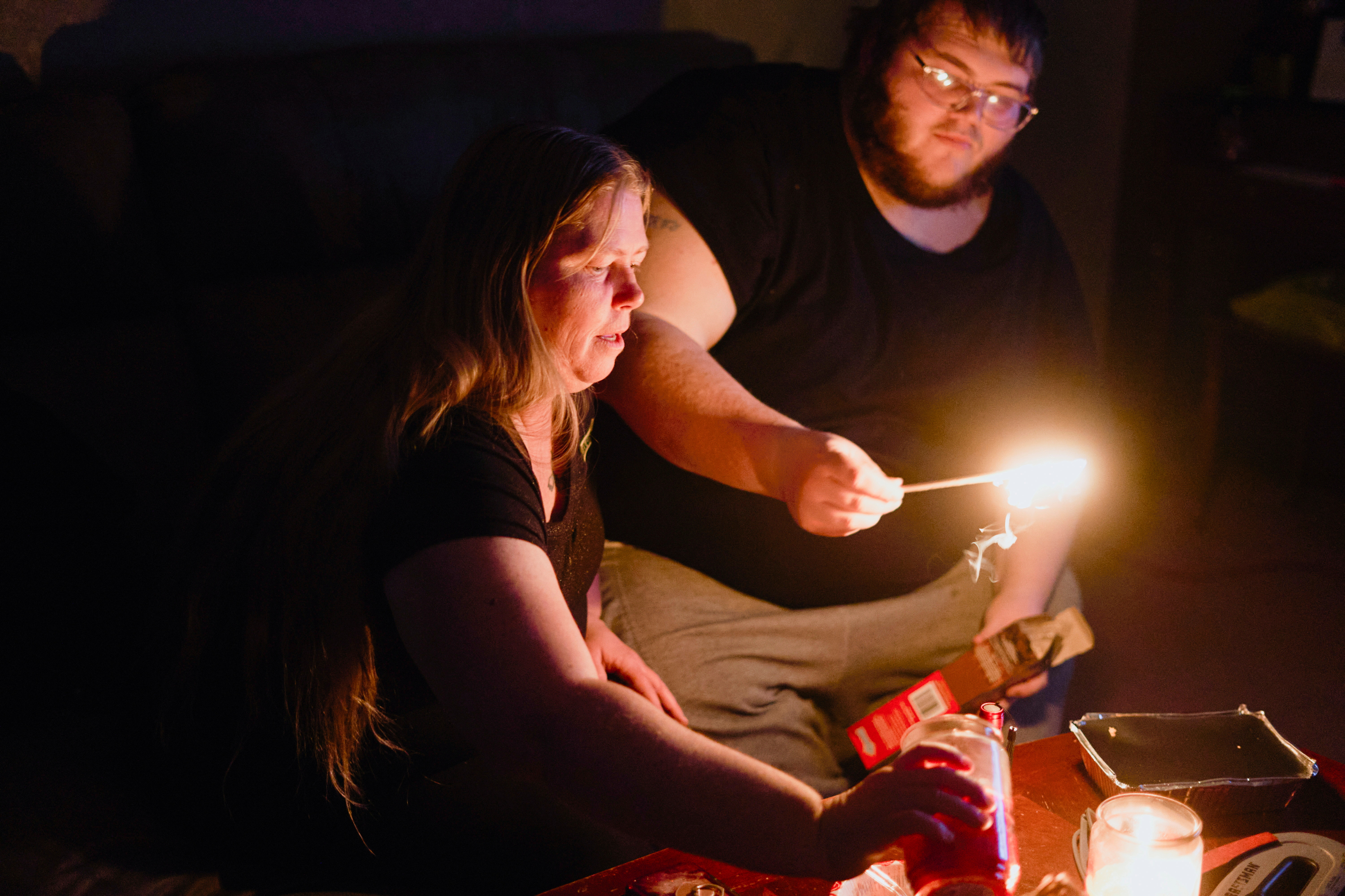 Christina Beverly and John Shearon light candles in their home after winter weather caused electricity blackouts and "boil water" notices in Fort Worth, Texas, U.S. February 20, 2021. Their home has not had power since blackouts began across the state on Sunday, February 14, 2021, according to the residents. REUTERS/Cooper Neill