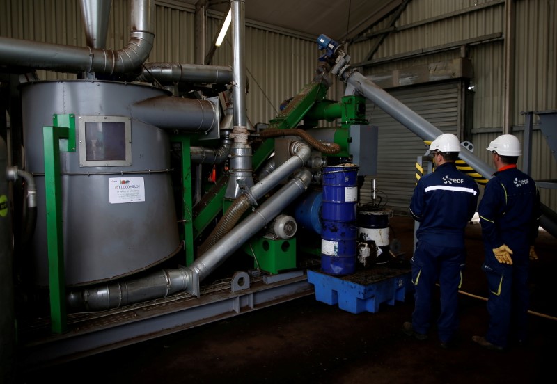 Employees of the Electricite de France (EDF) work on a prototype manufacturing densified biomass pellets at the Electricite de France (EDF) coal-fired power plant in Cordemais