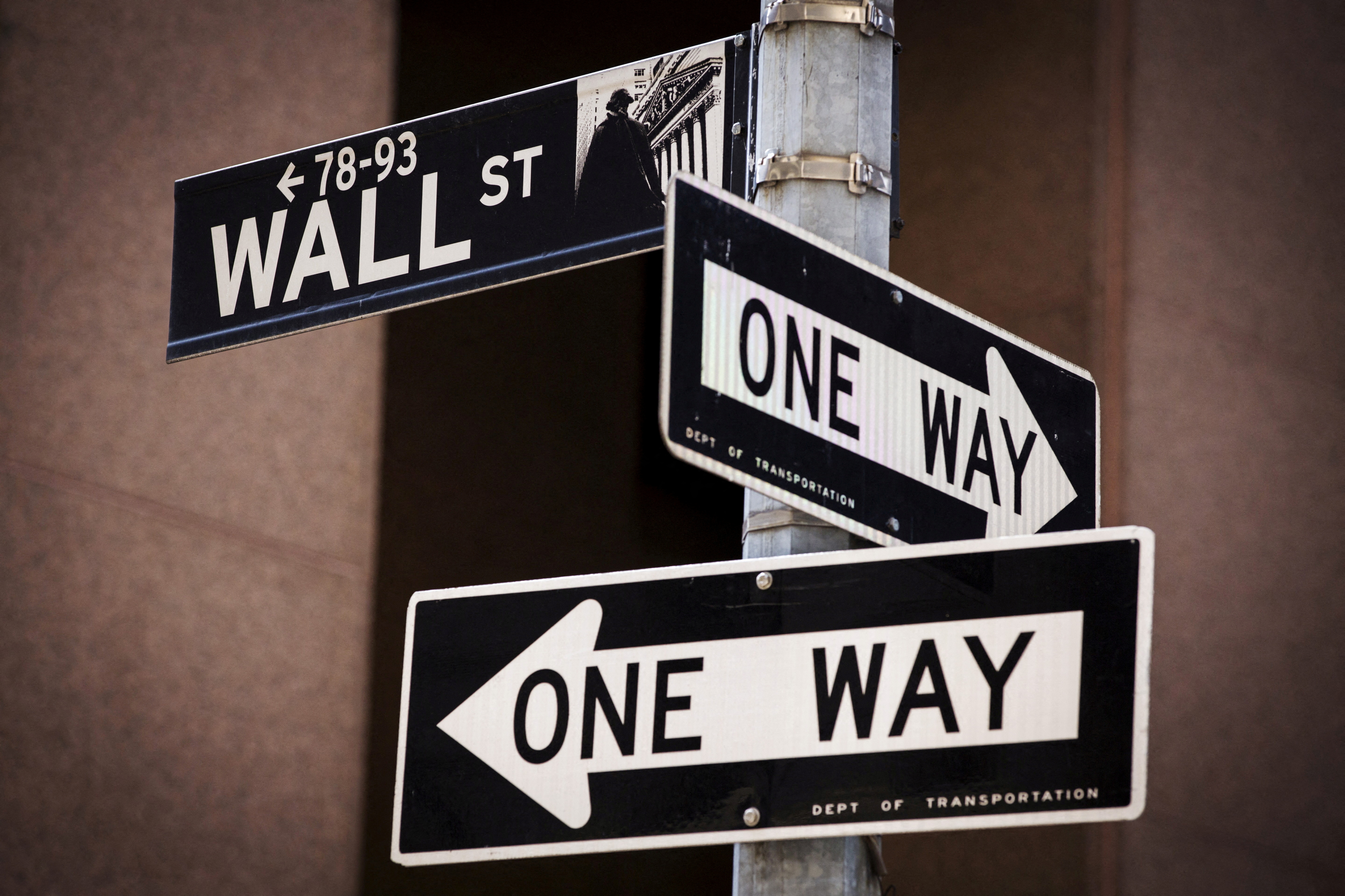 A 'Wall St' sign is seen above two 'One Way' signs in New York August 24, 2015. REUTERS/Lucas Jackson/File Photo