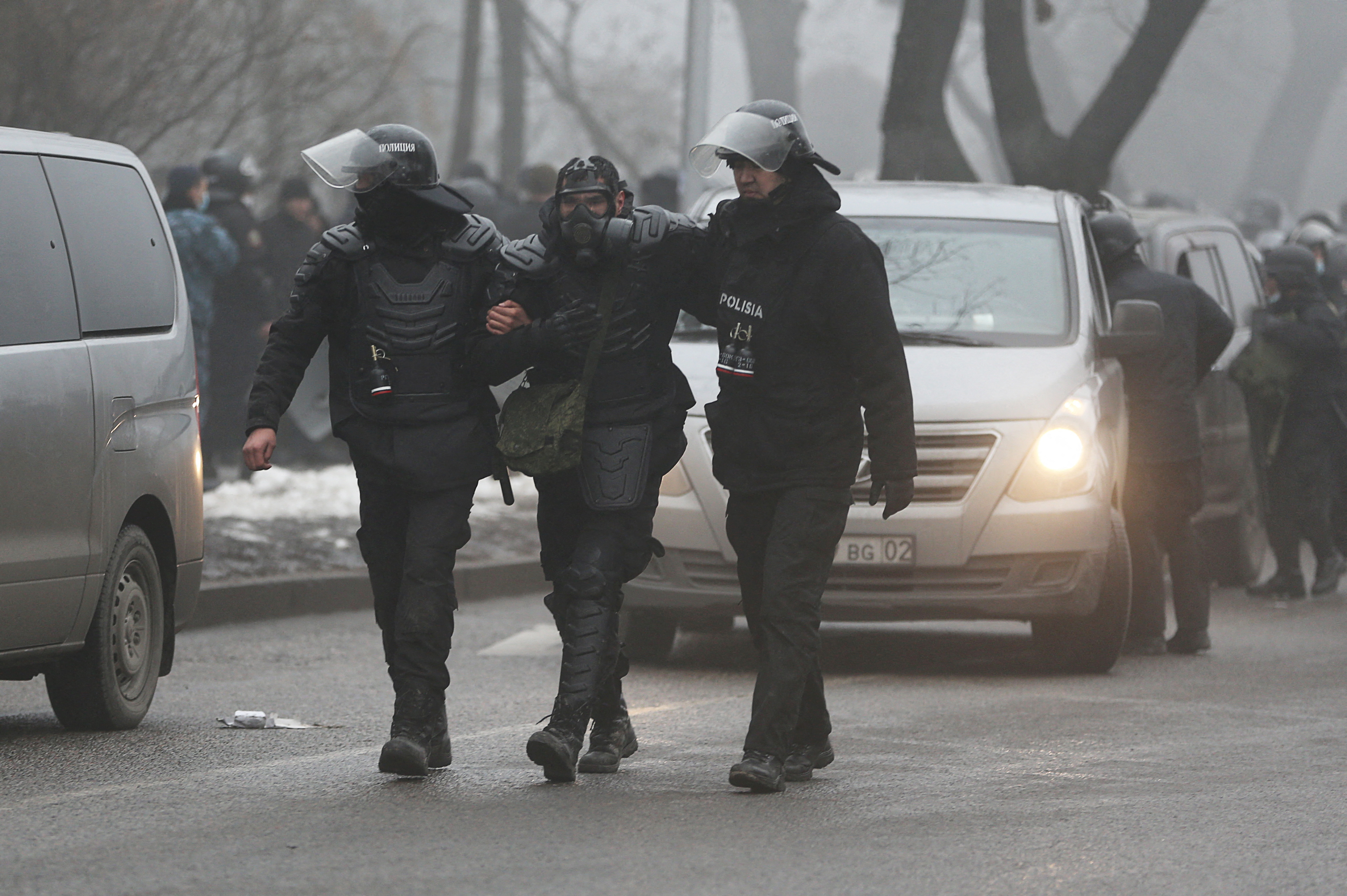 A Kazakh law enforcement officer is assisted during a protest triggered by fuel price increase in Almaty, Kazakhstan January 5, 2022. REUTERS/Pavel Mikheyev