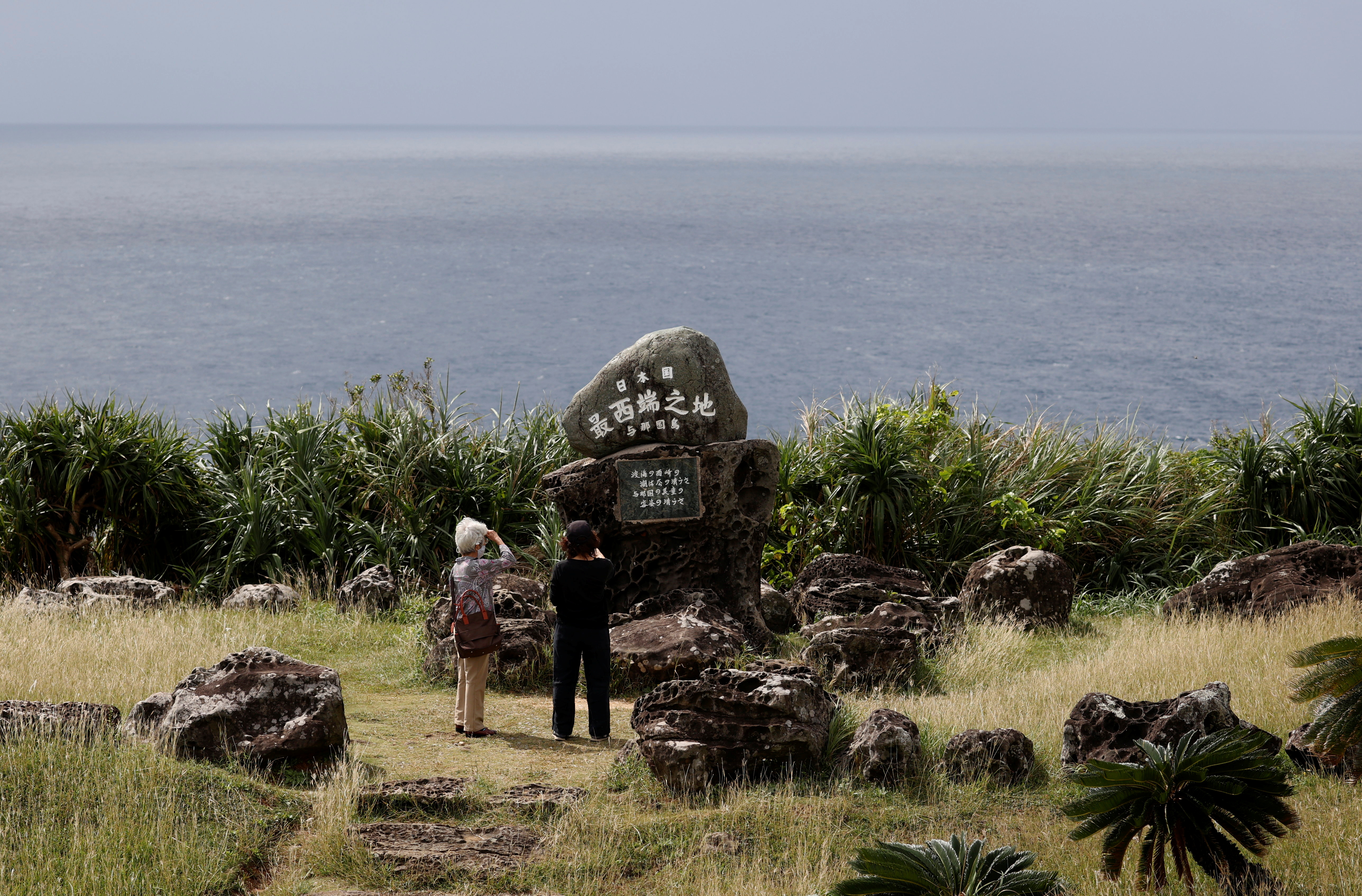 People enjoy the view of the East China Sea next to the monument of Japan's westernmost point on Yonaguni Island in Yonaguni, Okinawa