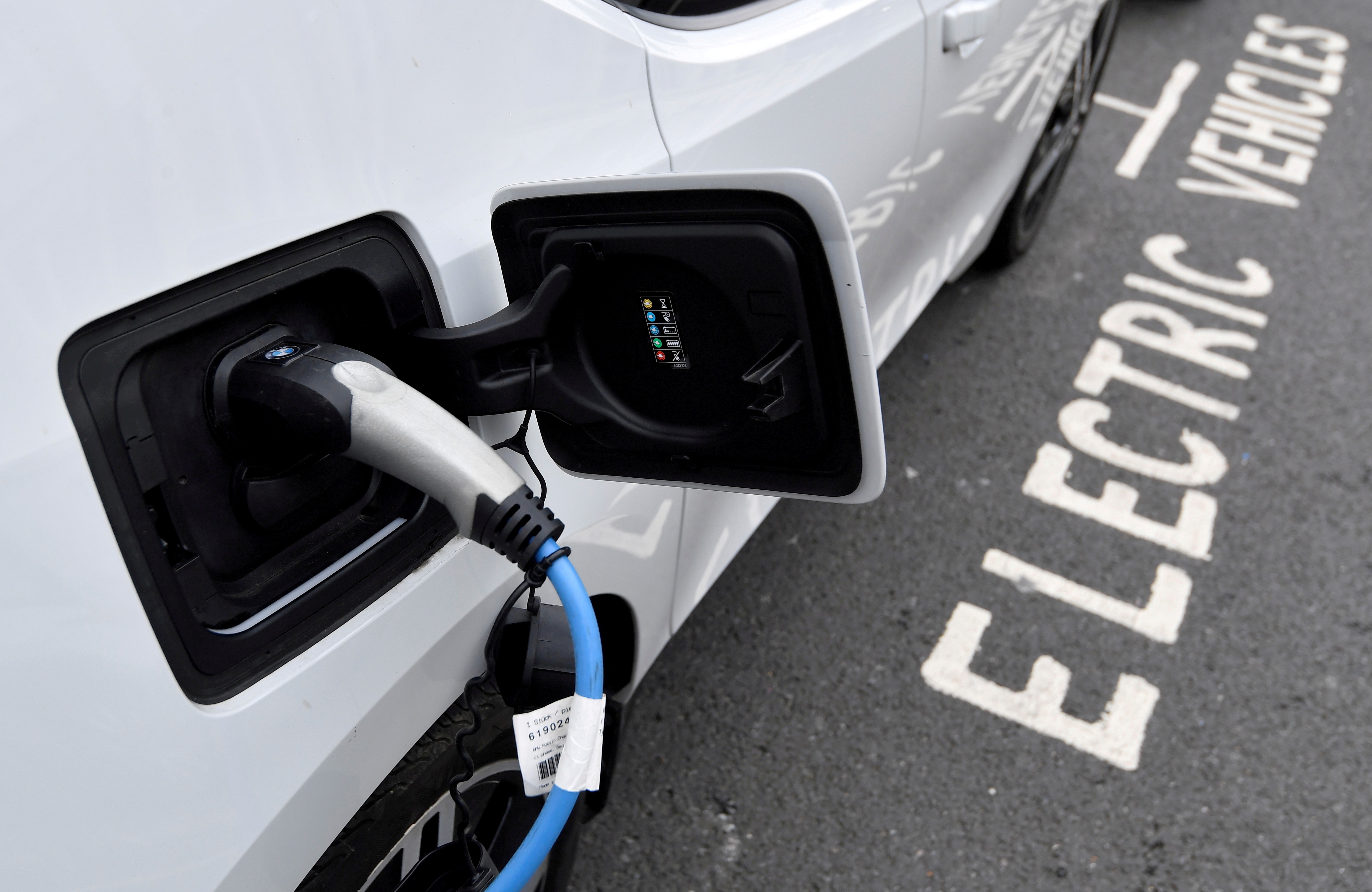 An electric car is charged at a roadside EV charge point, London, October 19, 2021. REUTERS/Toby Melville/File Photo