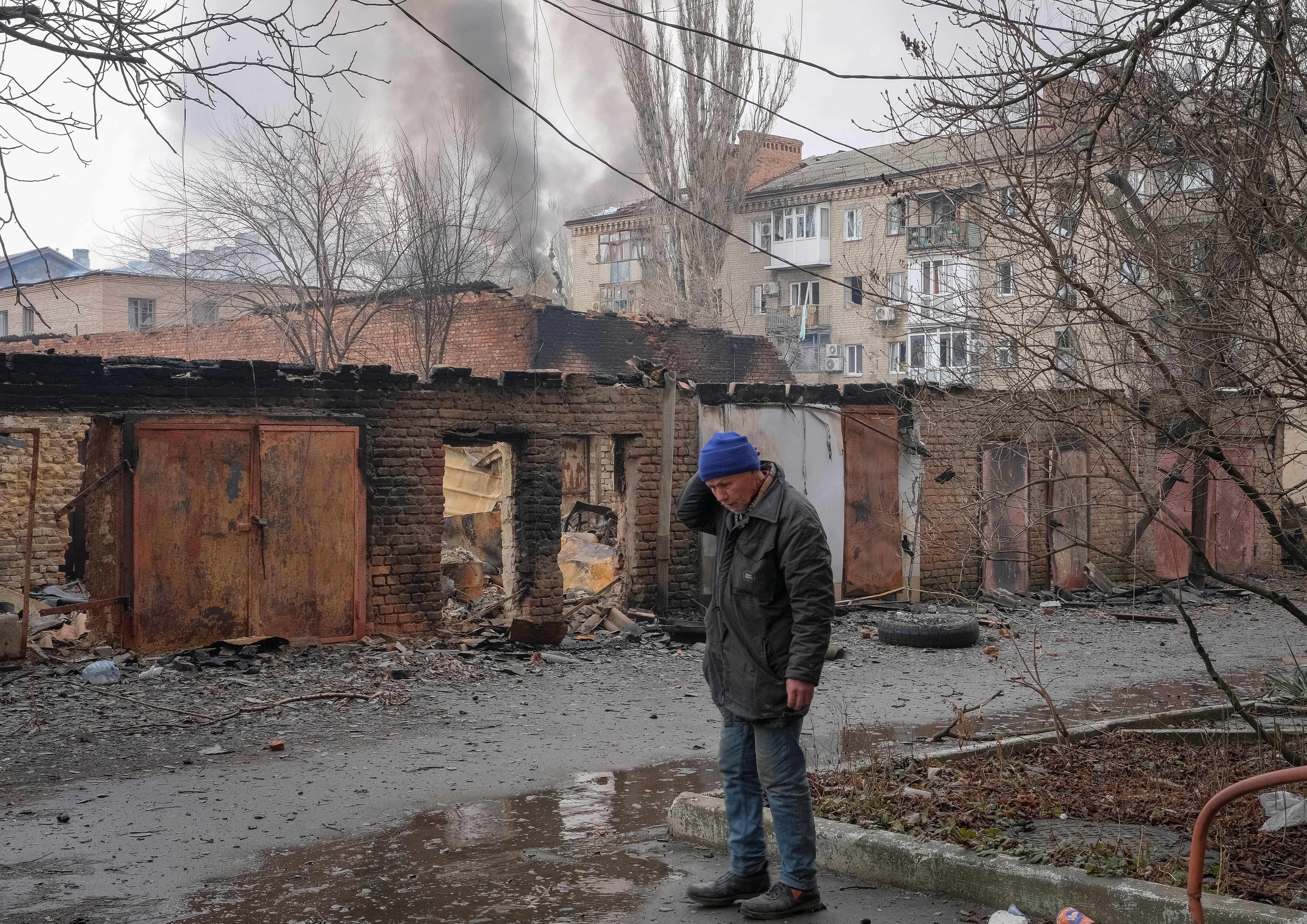 A local resident stands near buildings damaged by a Russian military strike in Bakhmut