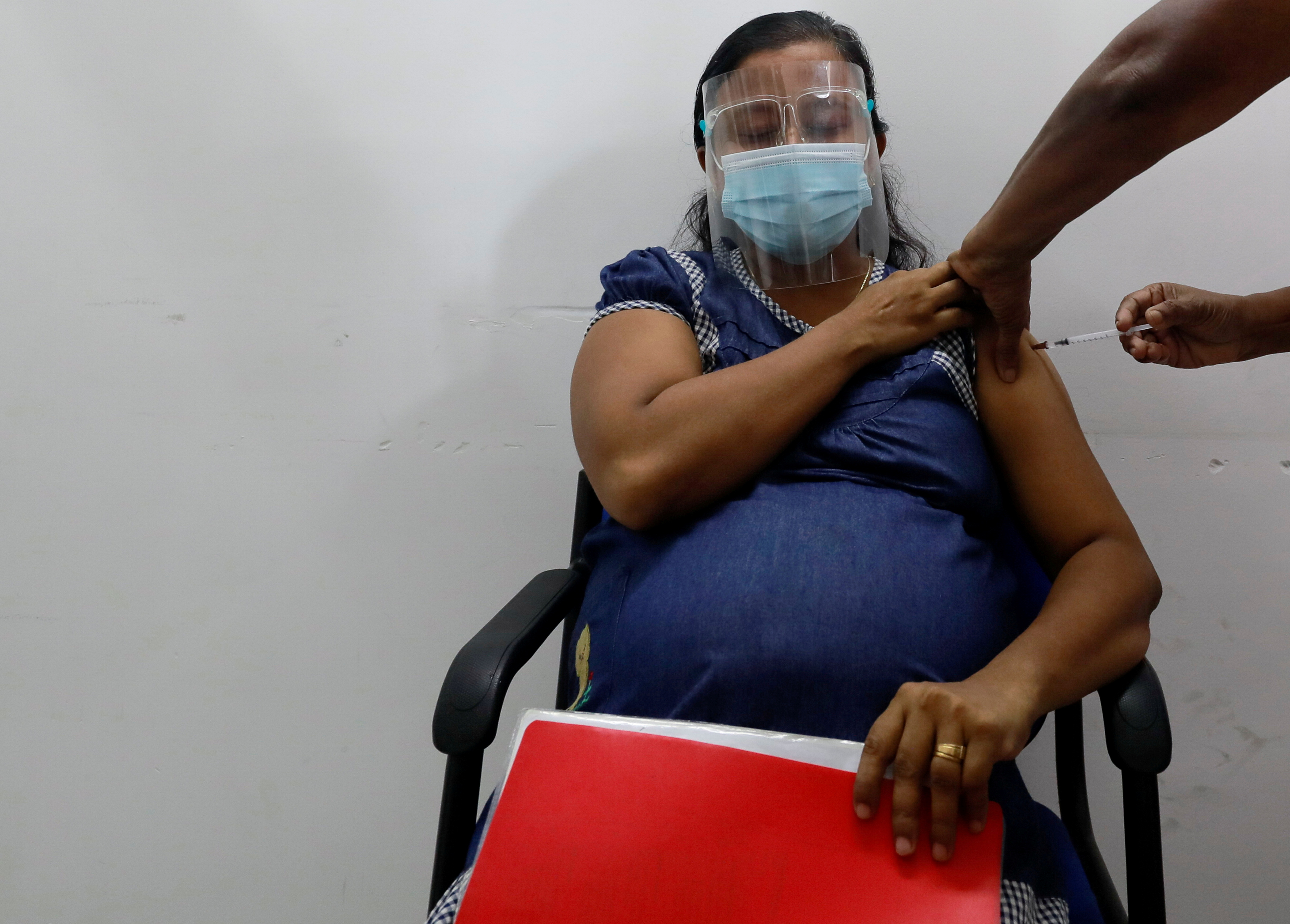 A pregnant woman receives a dose of Sinopharm vaccine against the coronavirus disease (COVID-19) during the launching ceremony of the vaccination for pregnant women in the country, in Piliyandala suburb, Colombo Sri Lanka June 9, 2021. REUTERS/Dinuka Liyanawatte/File Photo