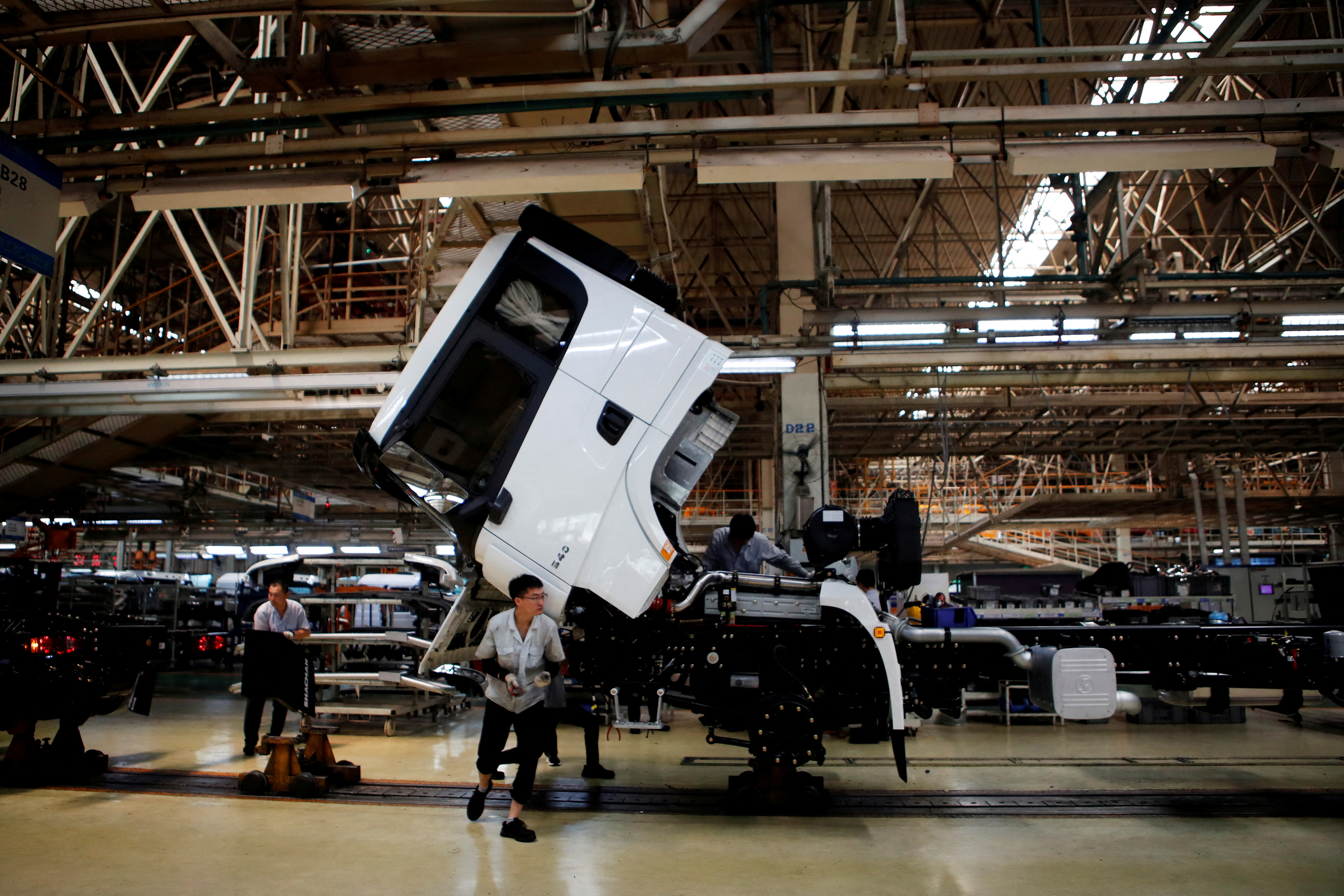 Employees work on the trucks production line at Shaanxi Automobile Group in Xian