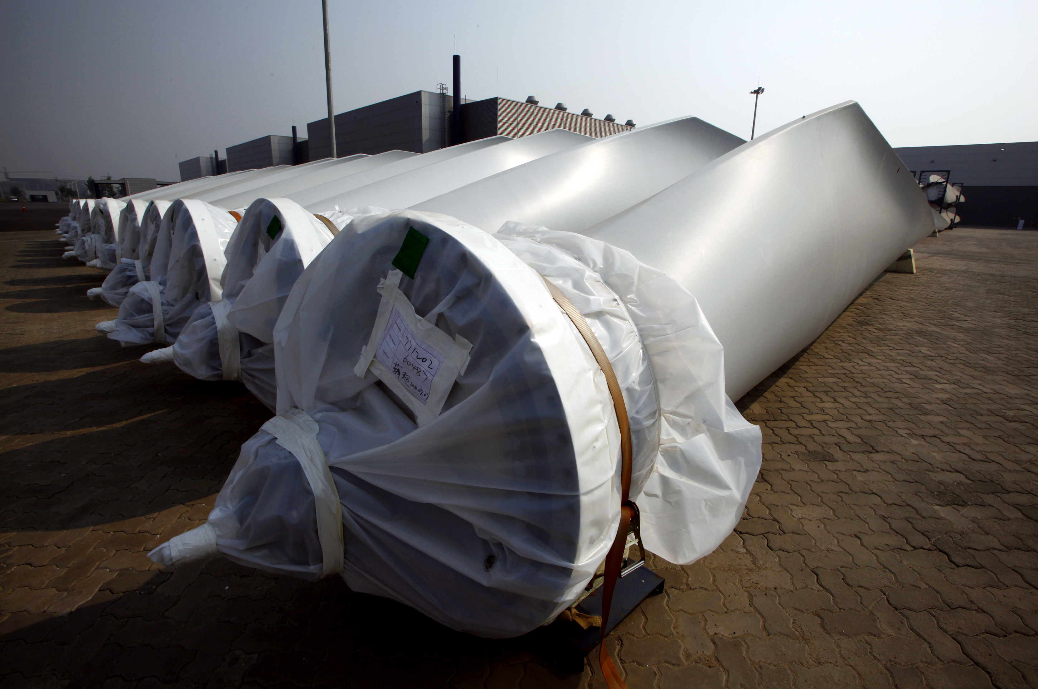 Blades for wind-turbines can be seen in the grounds of the Vestas Wind Technology company's factory in Tianjin