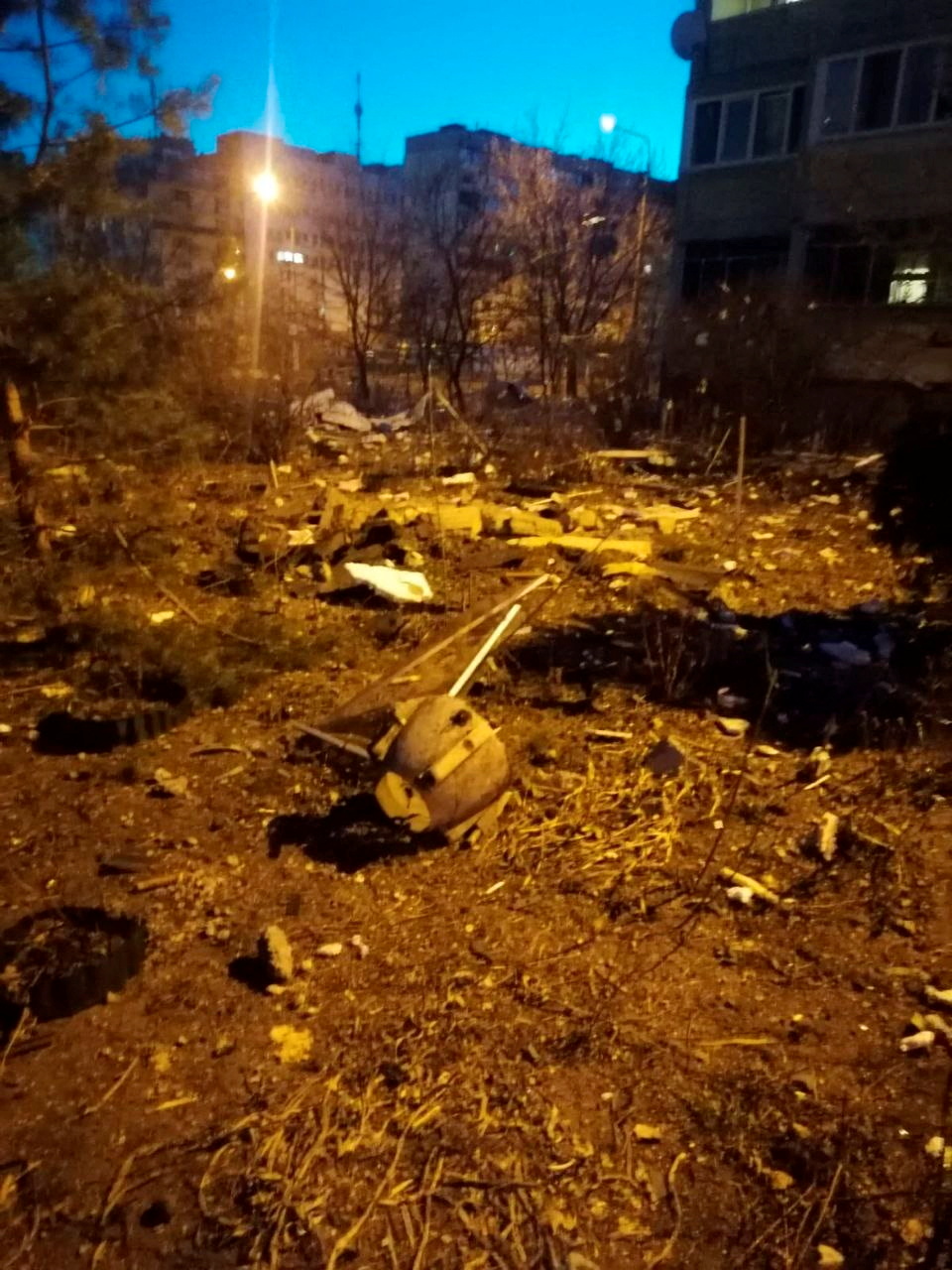 Debris lies scattered on the ground after the remains of a downed missile damaged a residential building, in Kyiv