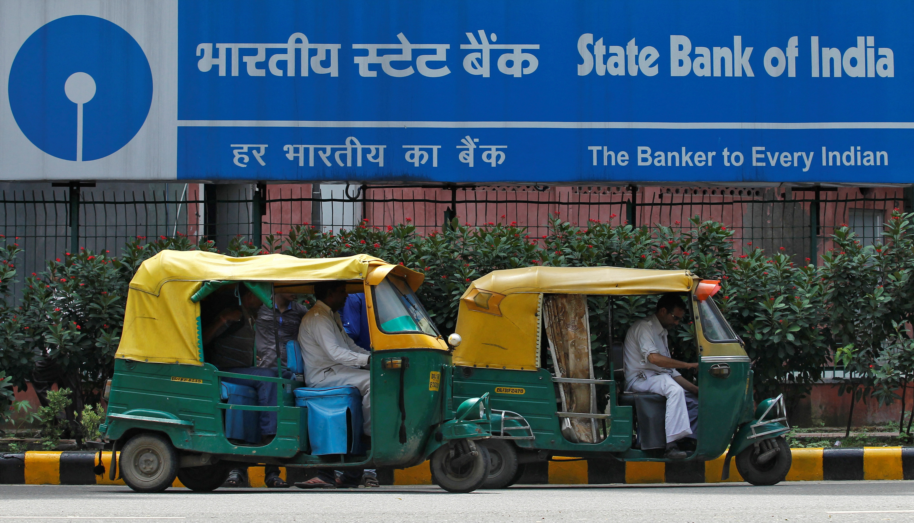 Auto rickshaws wait in front of the head office of State Bank of India in New Delhi