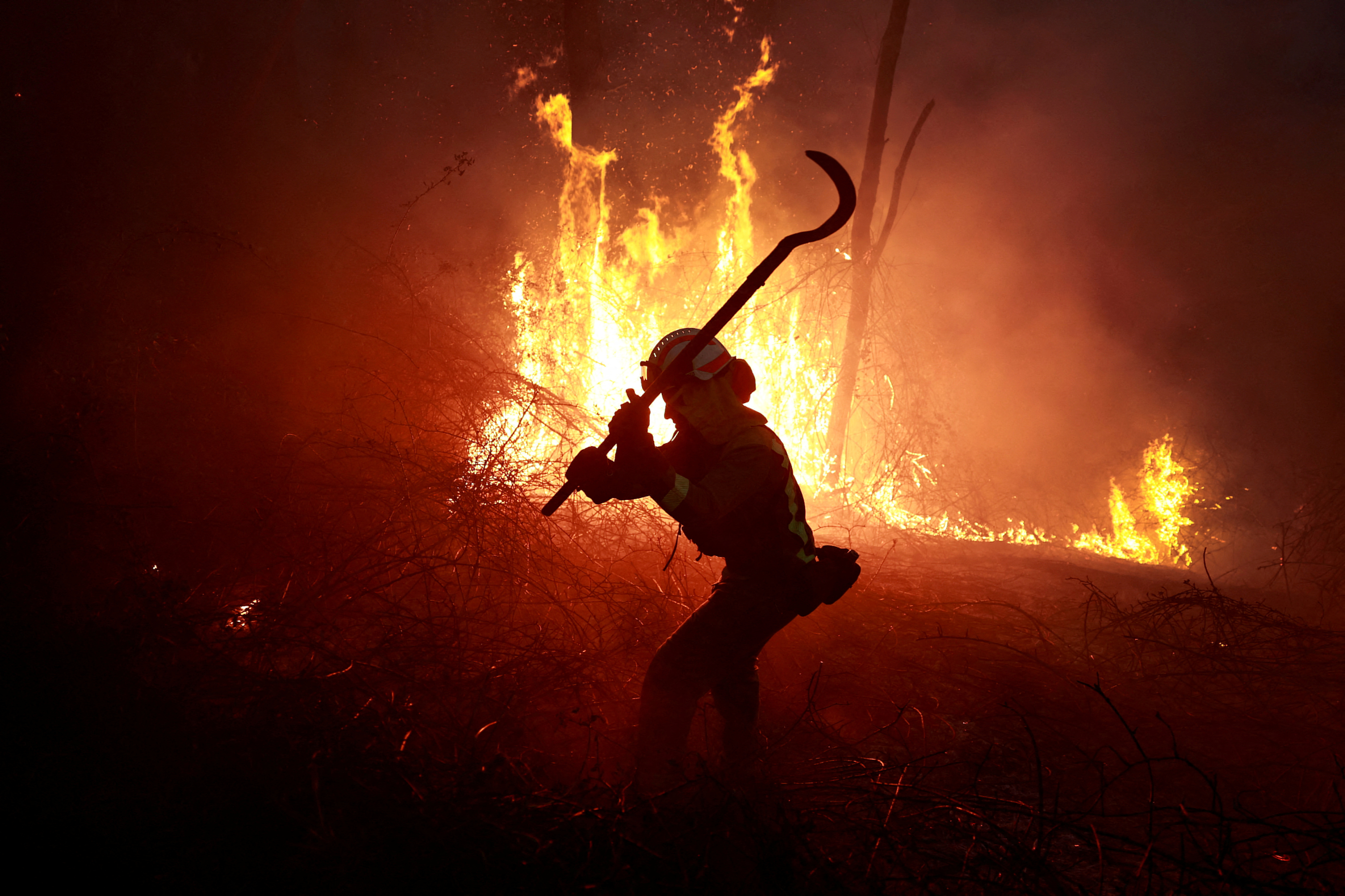 A firefighter from Galicia tackles a forest blaze near the Asturian village of Piedrafita
