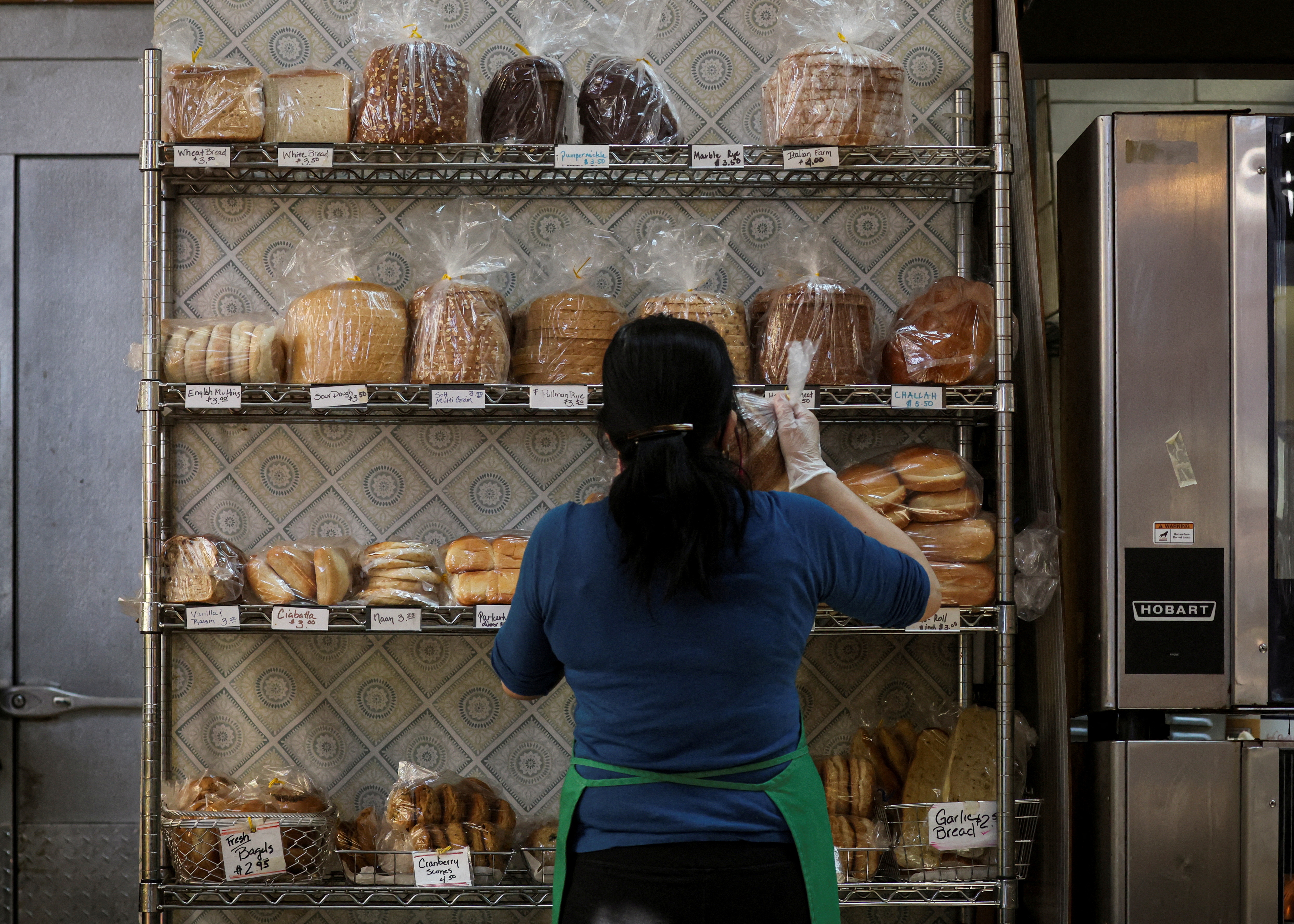 A baker stocks shelfs with bread at the Eastern Market in Washington