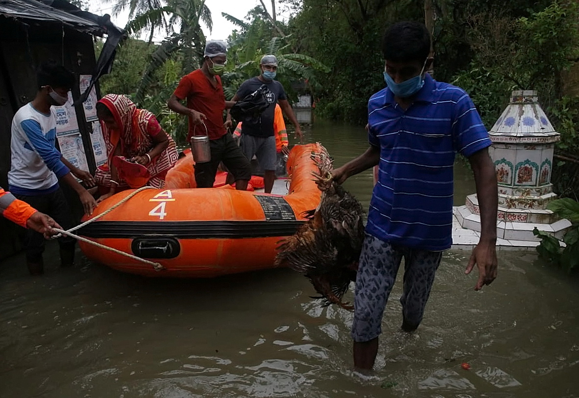 People are evacuated from a flooded area to safer places by the members of the National Disaster Response Force (NDRF) as Cyclone Yaas makes landfall at Ramnagar