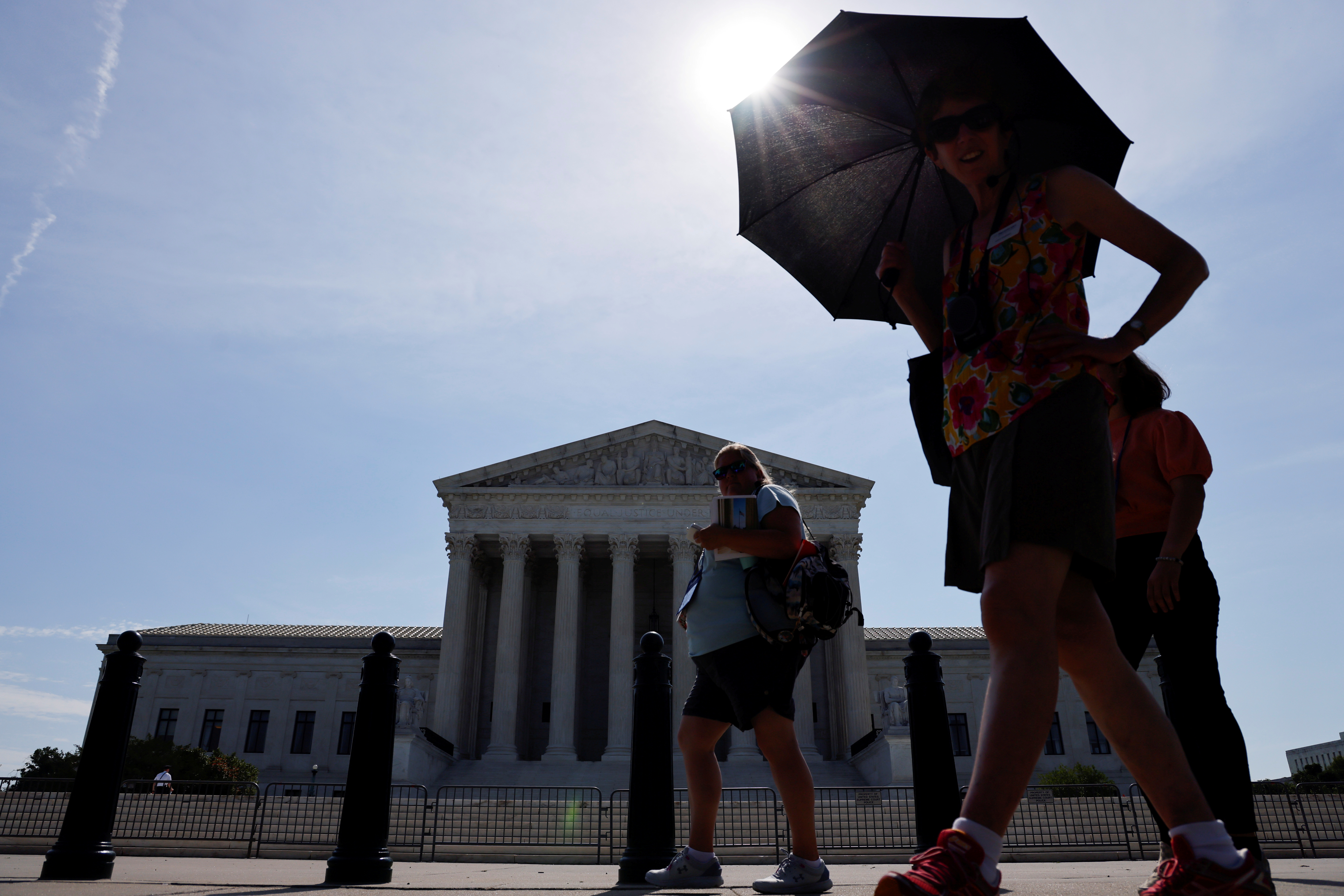 A tour group walks past the front of the U.S. Supreme Court building in Washington