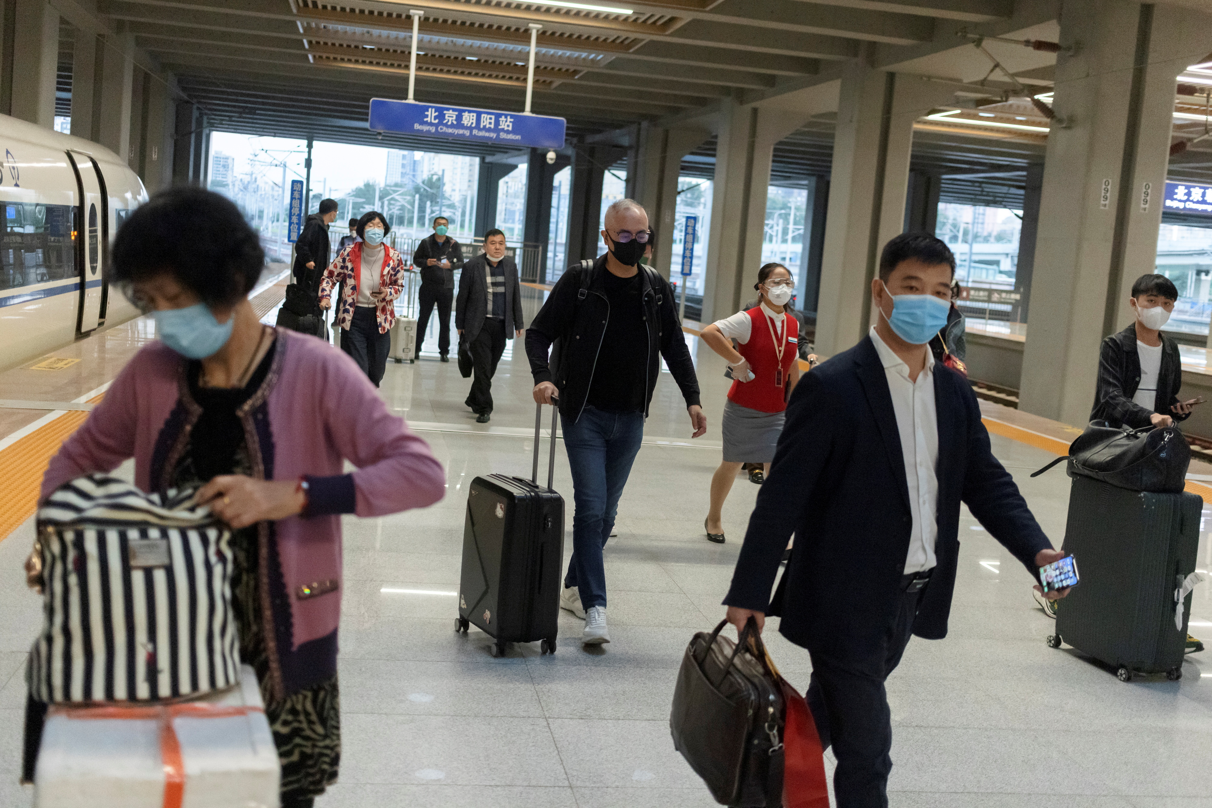 Travellers arrive at a train station ahead of China's upcoming Golden Week holiday following the coronavirus disease (COVID-19) outbreak, in Beijing