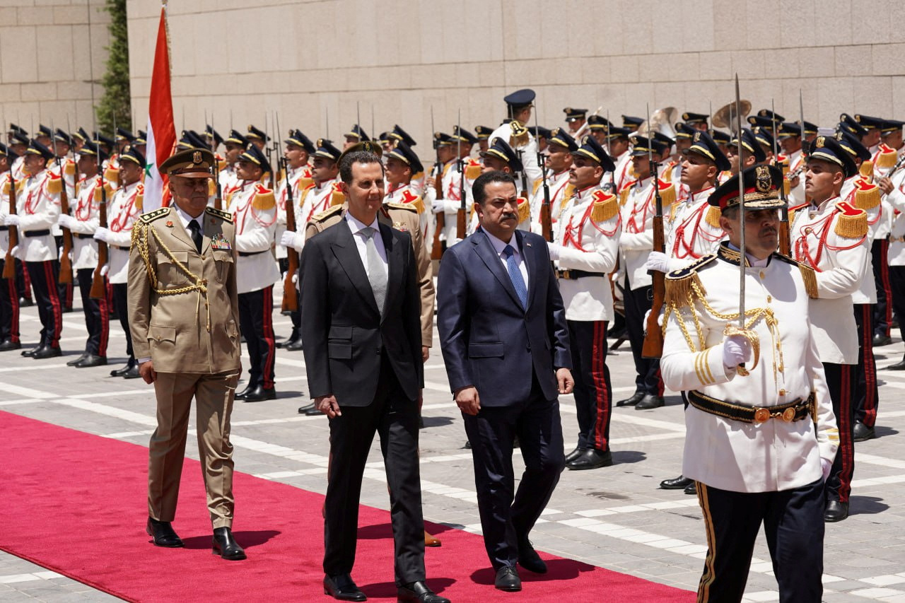 Syria's President Bashar al-Assad and Iraqi Prime Minister Mohammed Shia Al-Sudani review an honor guard in Damascus
