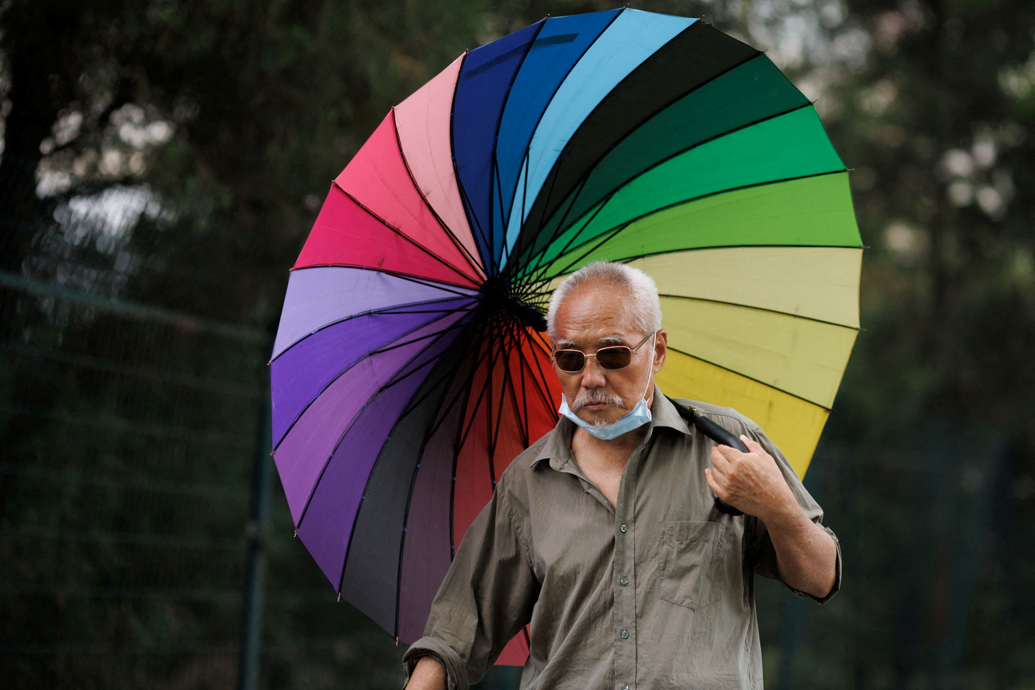 A man carries a parasol on a hot day on Summer Solstice in Beijing