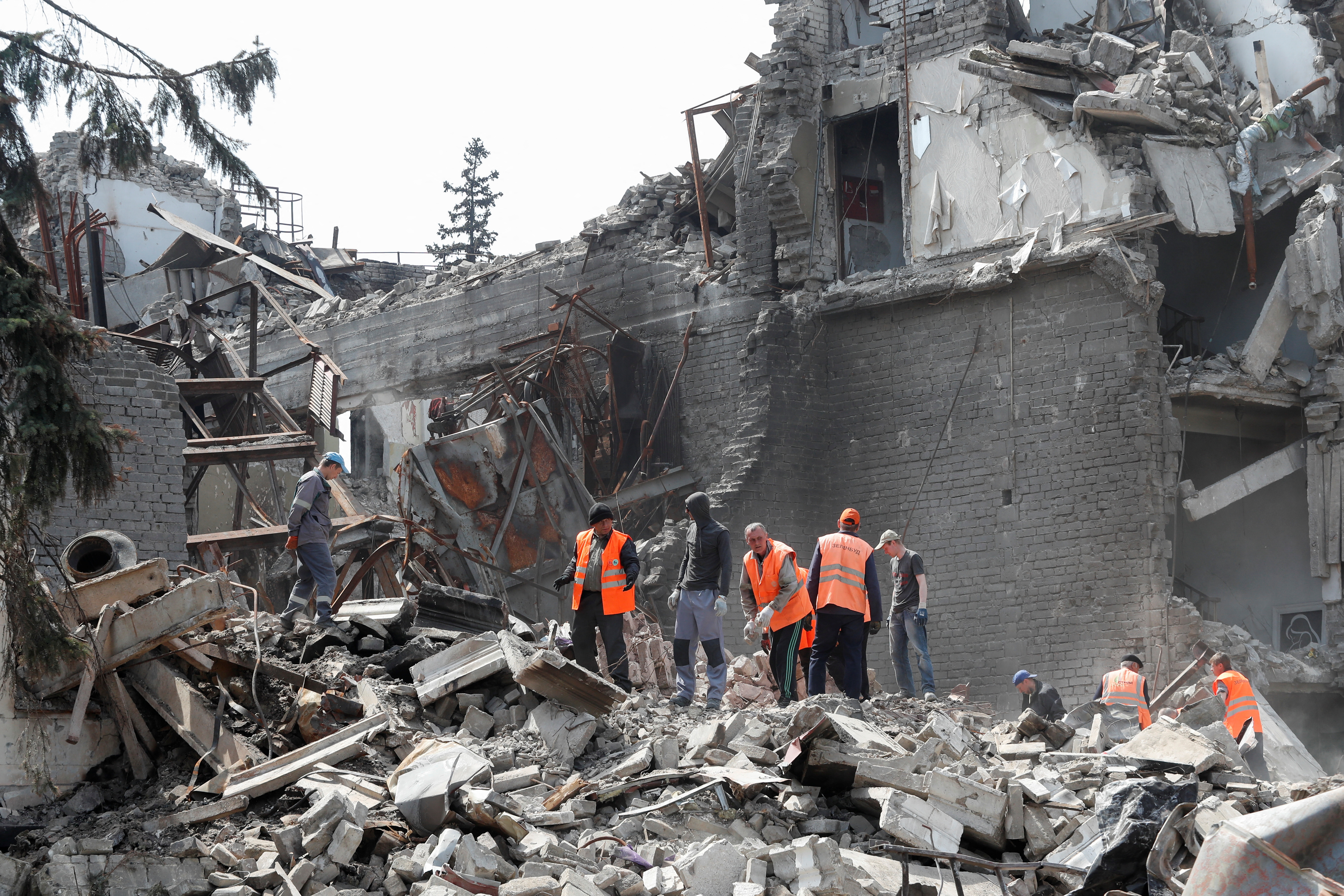 People remove the debris of a theatre building in Mariupol