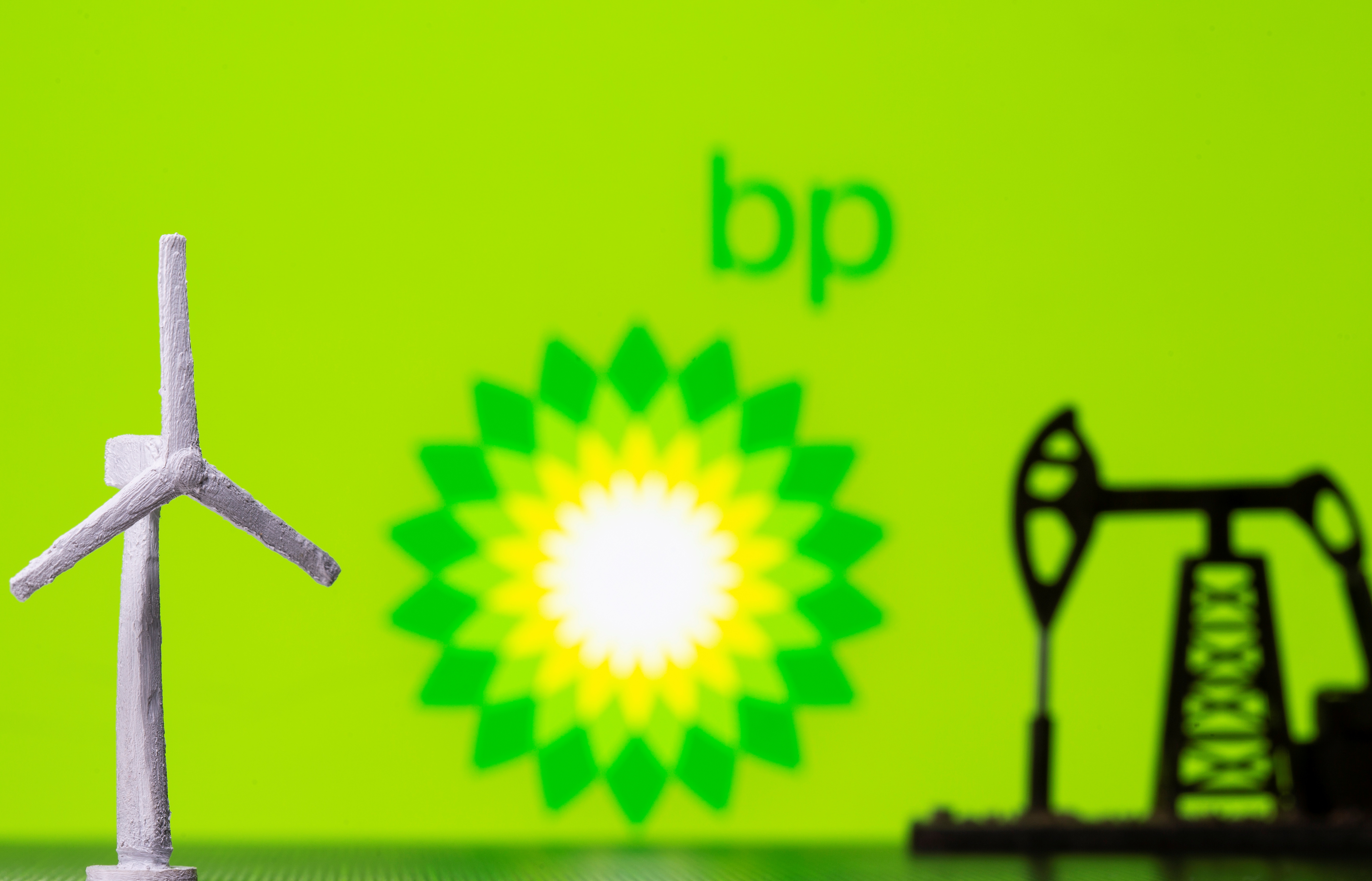 A 3D printed windmill and oil pump jack are seen in front of displayed BP (British Petroleum) logo in this illustration picture