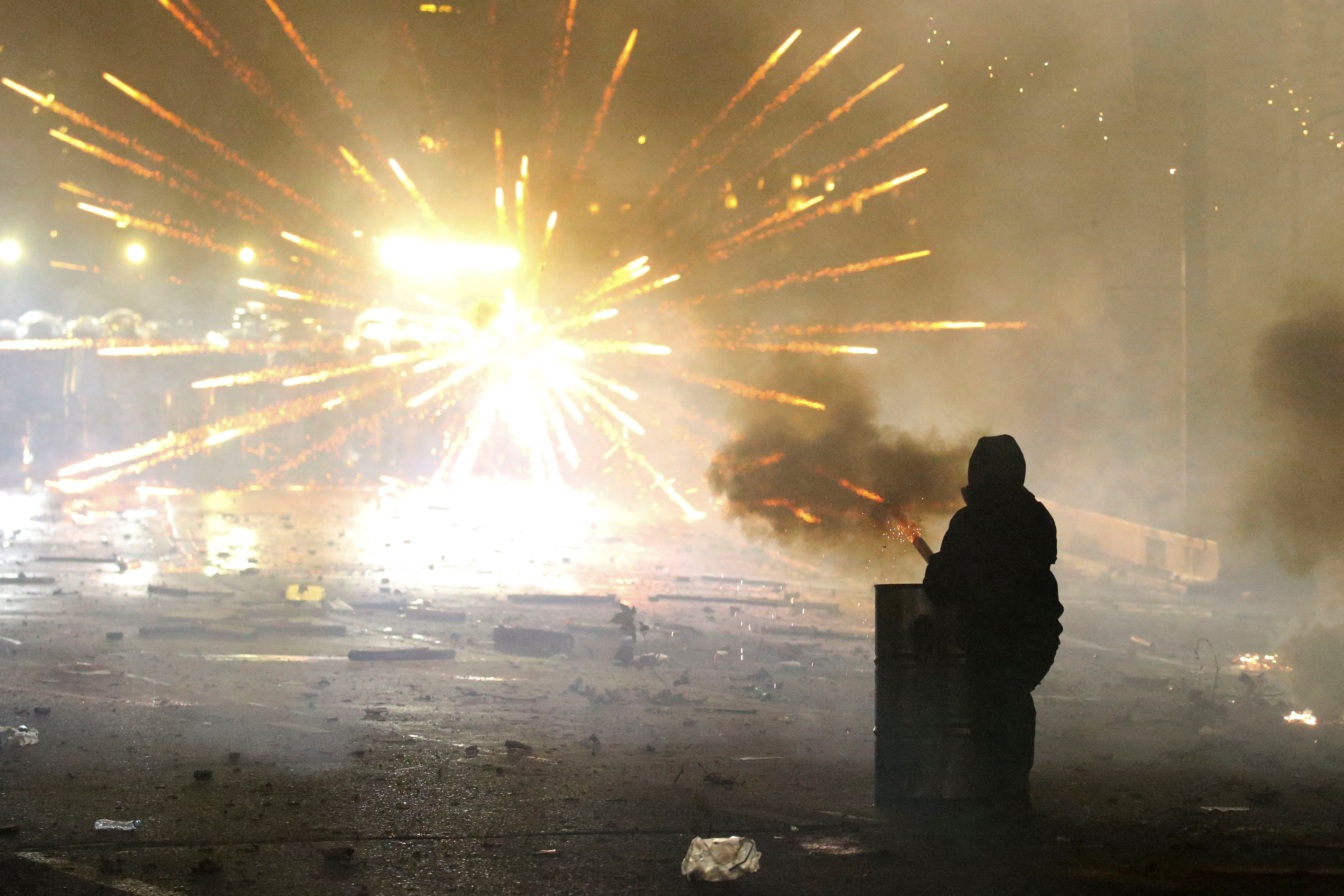 A demonstrator uses a handheld firework launcher during a rally to protest against the government's decision to suspend talks on joining the European Union, in Tbilisi, Georgia December 4, 2024. REUTERS/Irakli Gedenidze