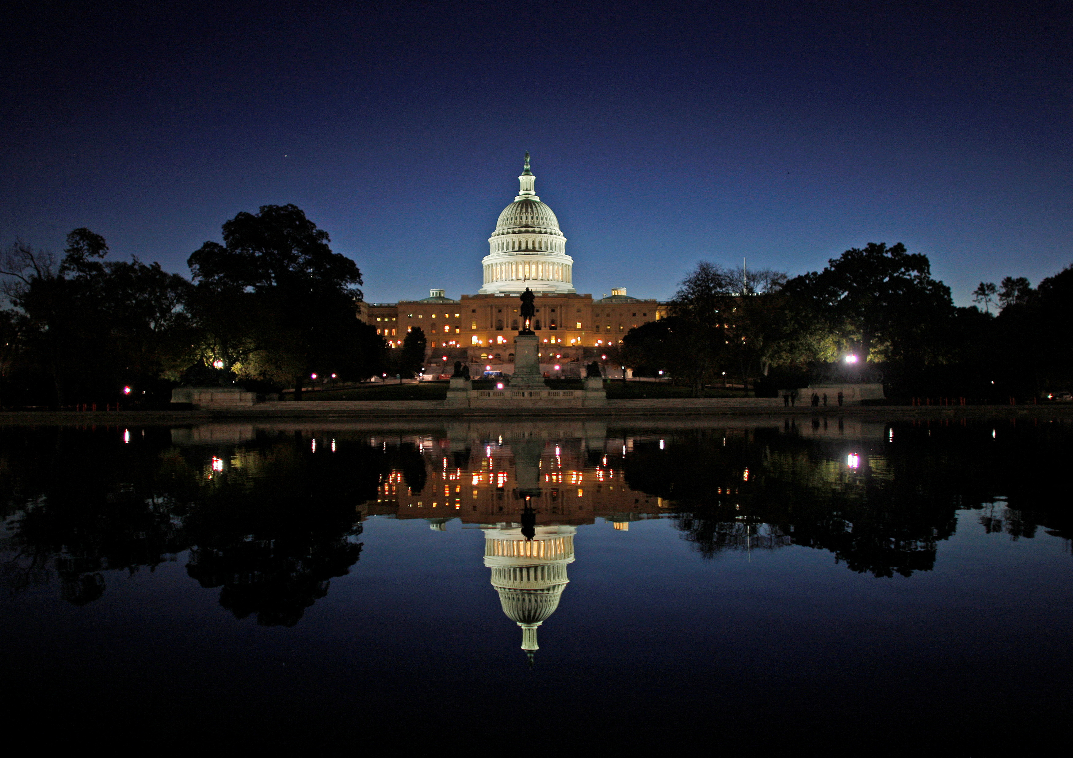 The United States Capitol Building is reflected in the water at sunrise in Washington