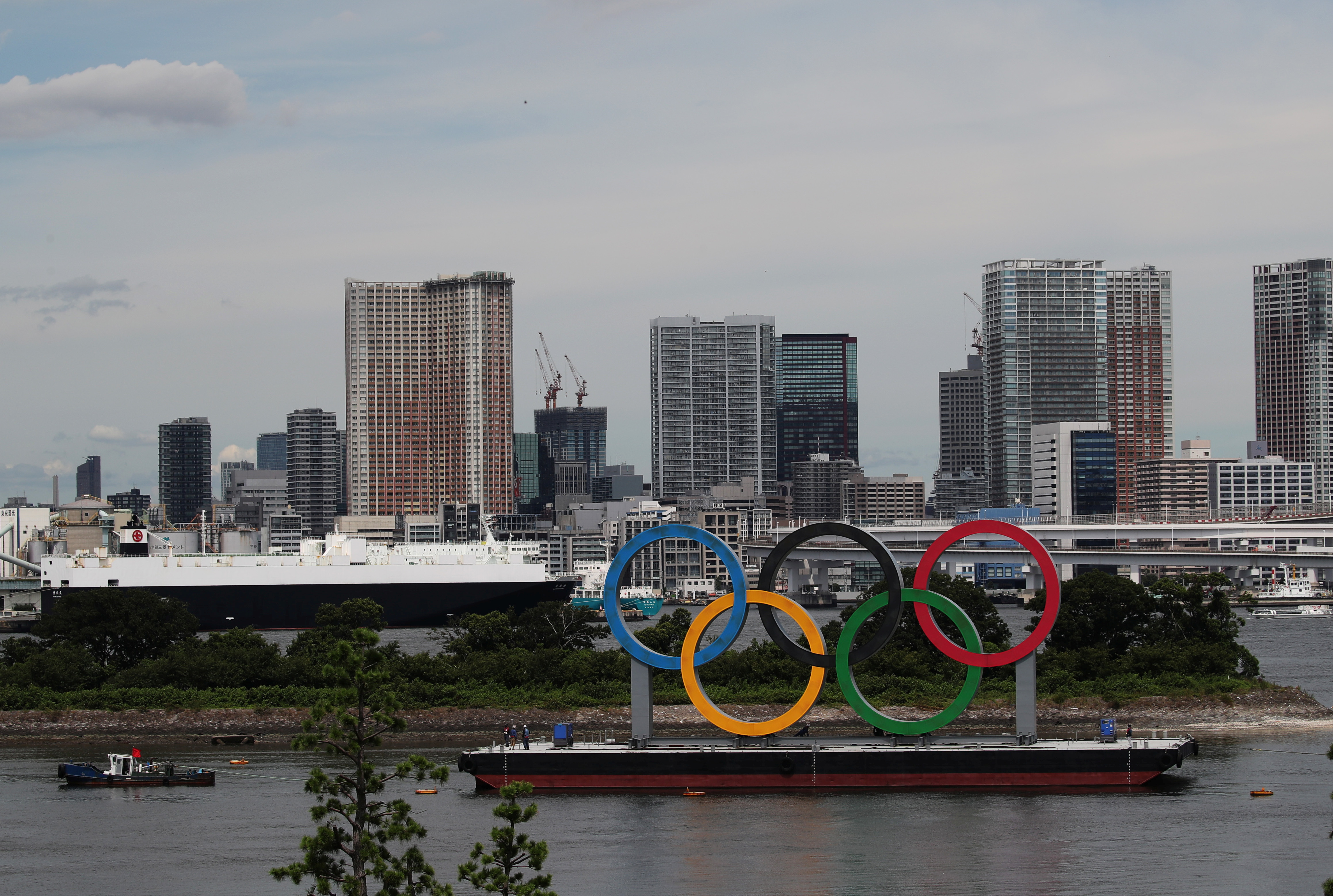 A boat tows giant Olympic rings as they are removed from the waterfront area at Odaiba Marine Park  in Tokyo