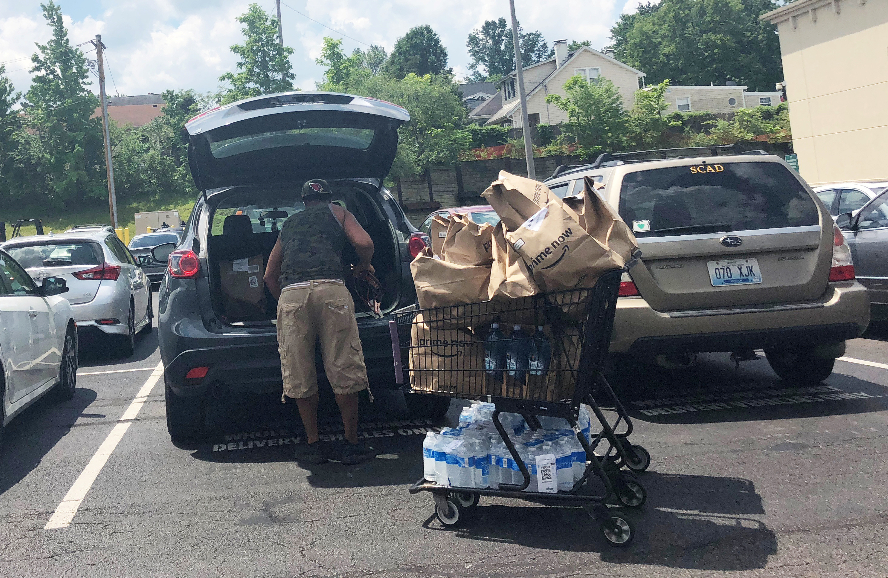 An Amazon driver loads Whole Foods delivery orders in his car in Cincinnati