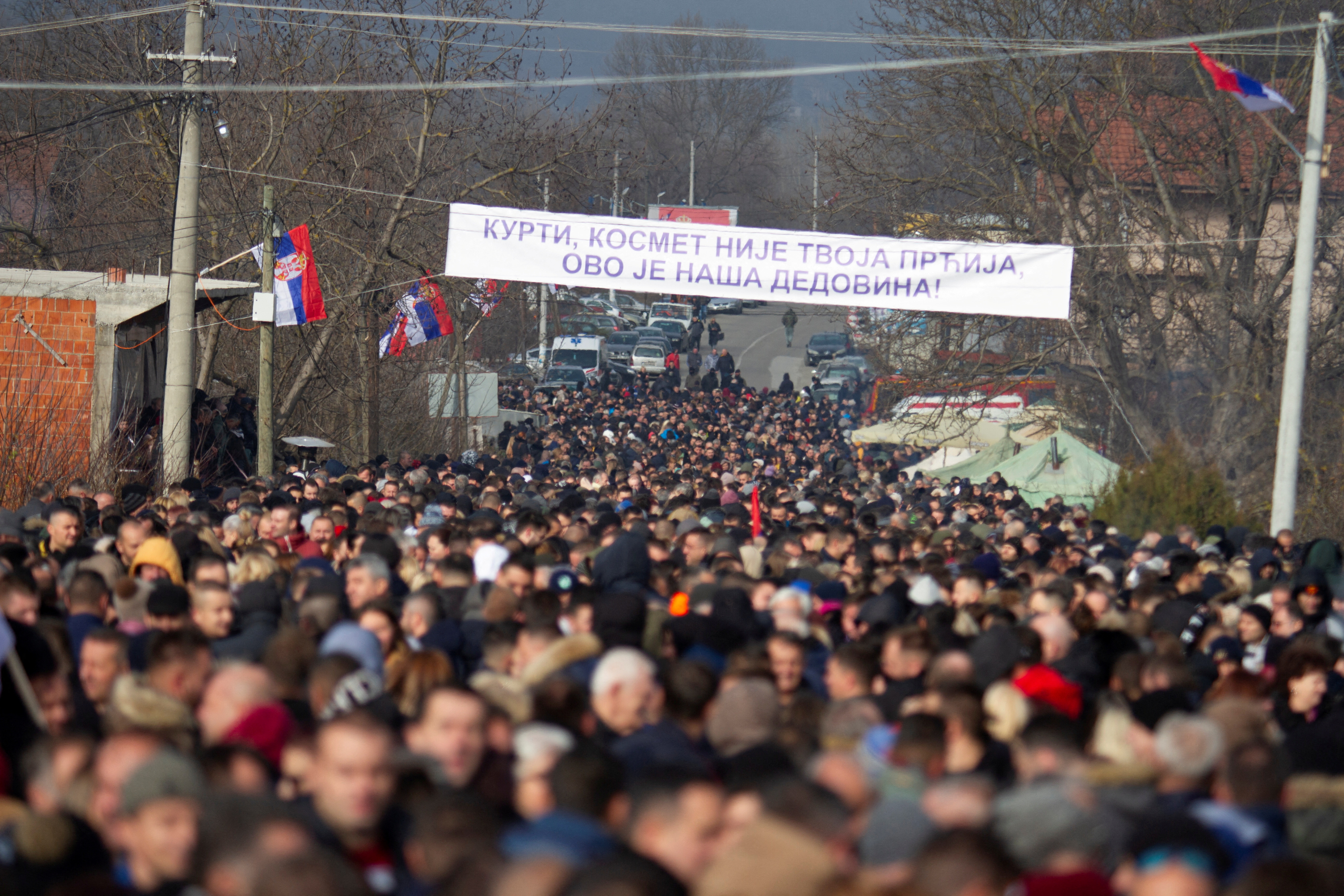 A banner reading “Kurti, Kosovo is not your turf it is our ancestral  land” is seen as local Serbs carry protest againsts the government near a roadblock in Rudare, Kosovo