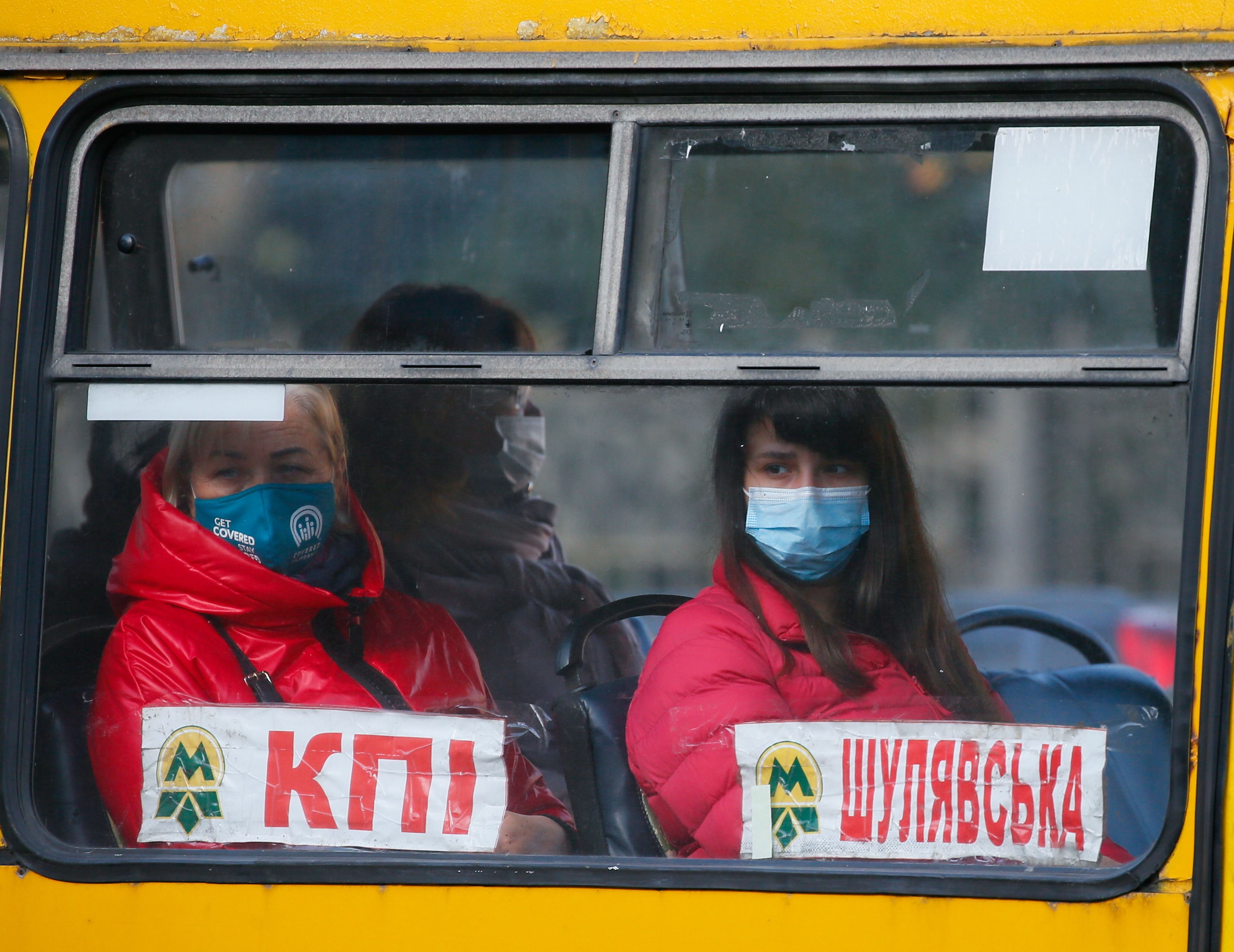 People wear protective face masks are seen in a bus in Kyiv
