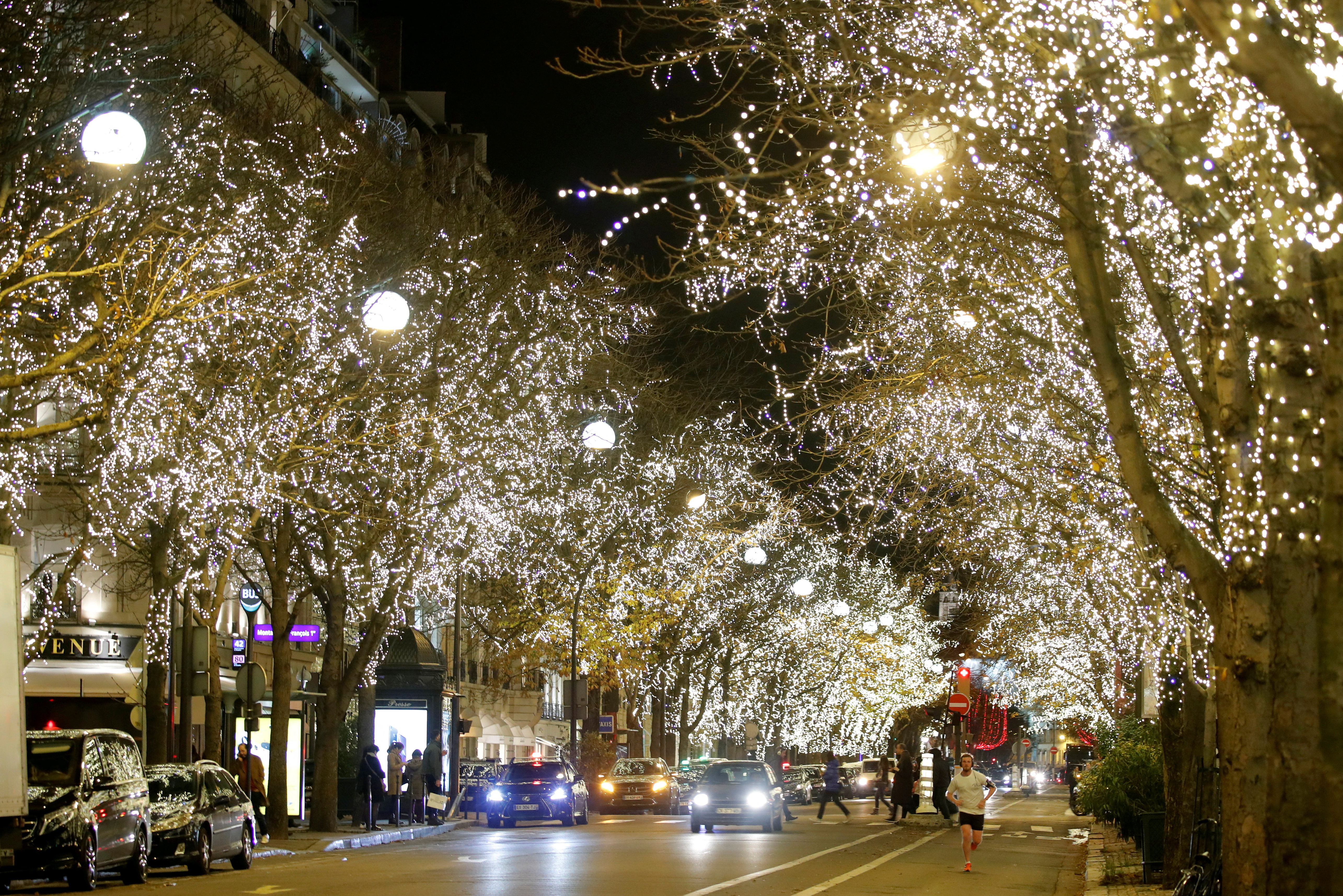 Trees are decorated with Christmas lights along the Montaigne Avenue during the holiday season in Paris