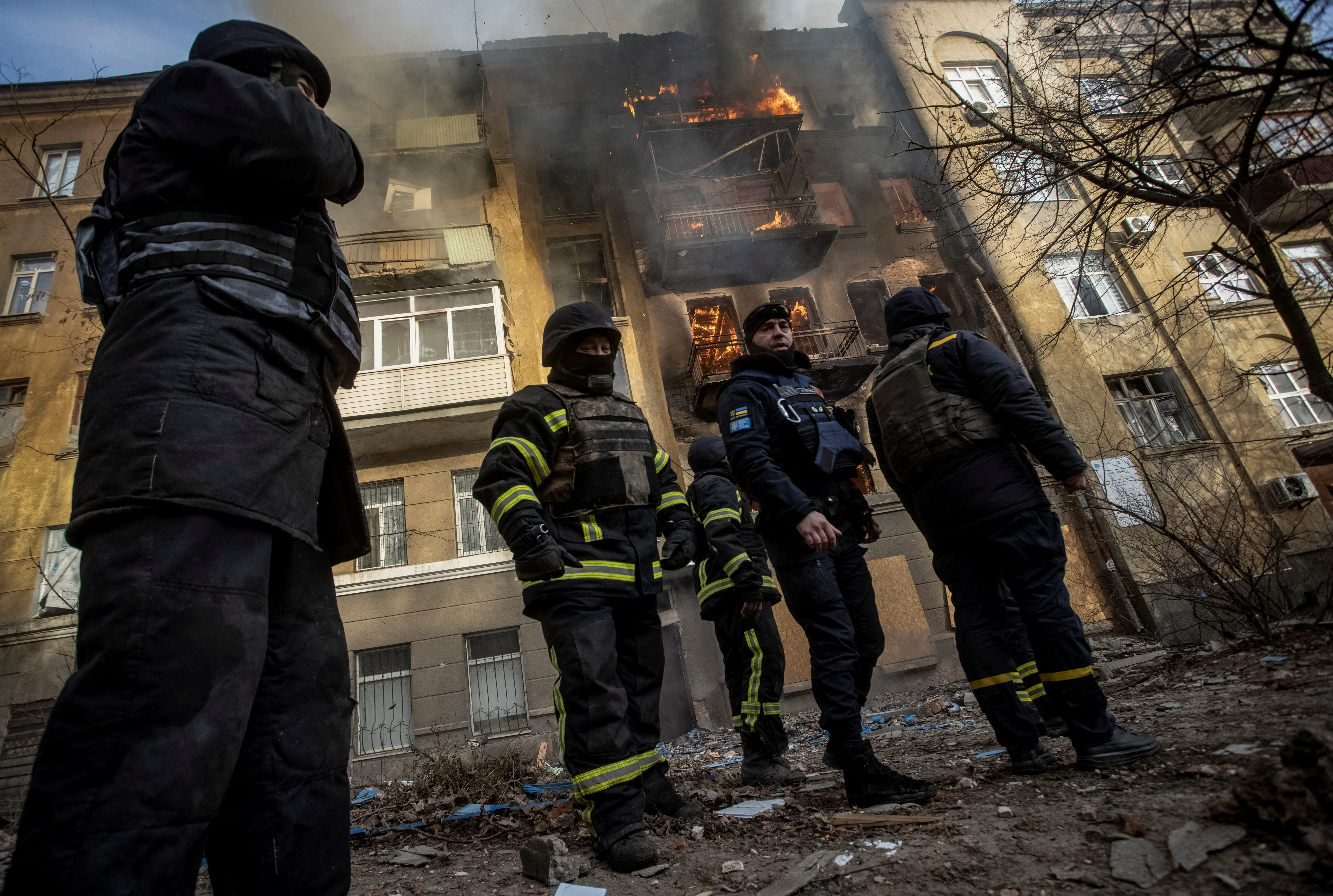 Пожарные тушат пожар в жилом доме, пострадавшем от обстрела российских войск в Пакмуте.