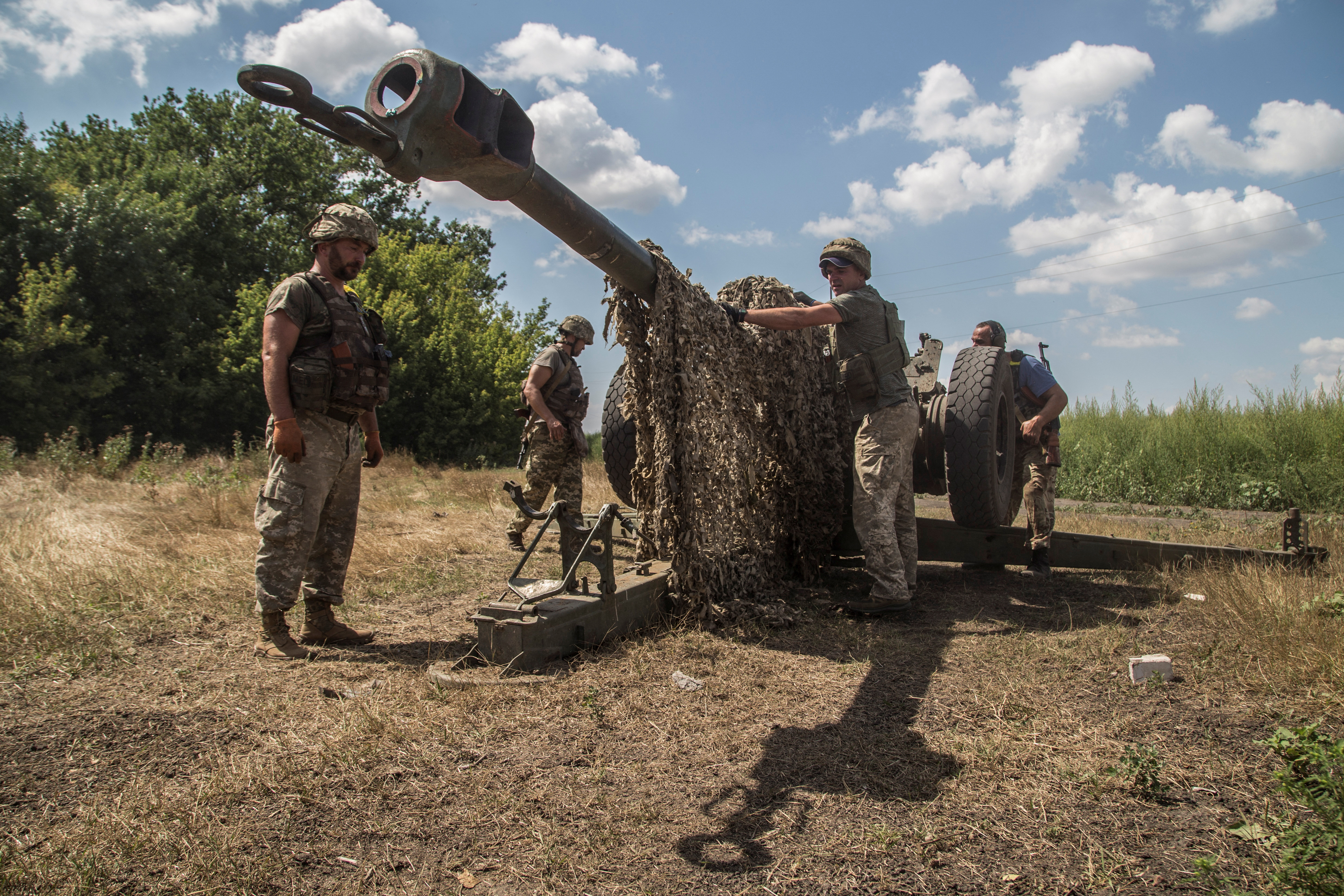 Ukrainian servicemen prepare a D-30 howitzer for fire near a frontline in Mykolaiv region