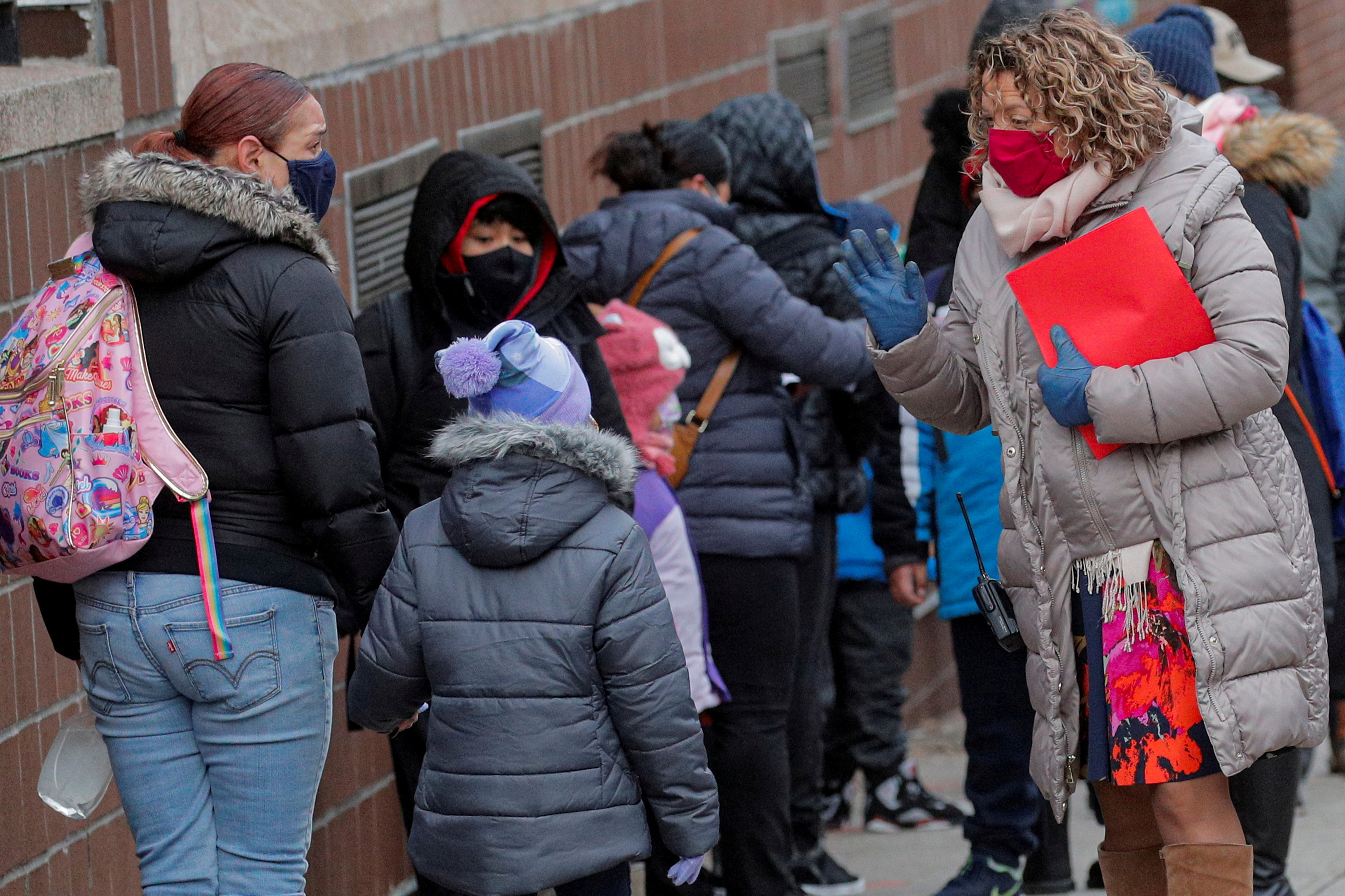 A principal greets students as they return to New York City's public schools for in-person learning at P.S. 506 in Brooklyn, New York