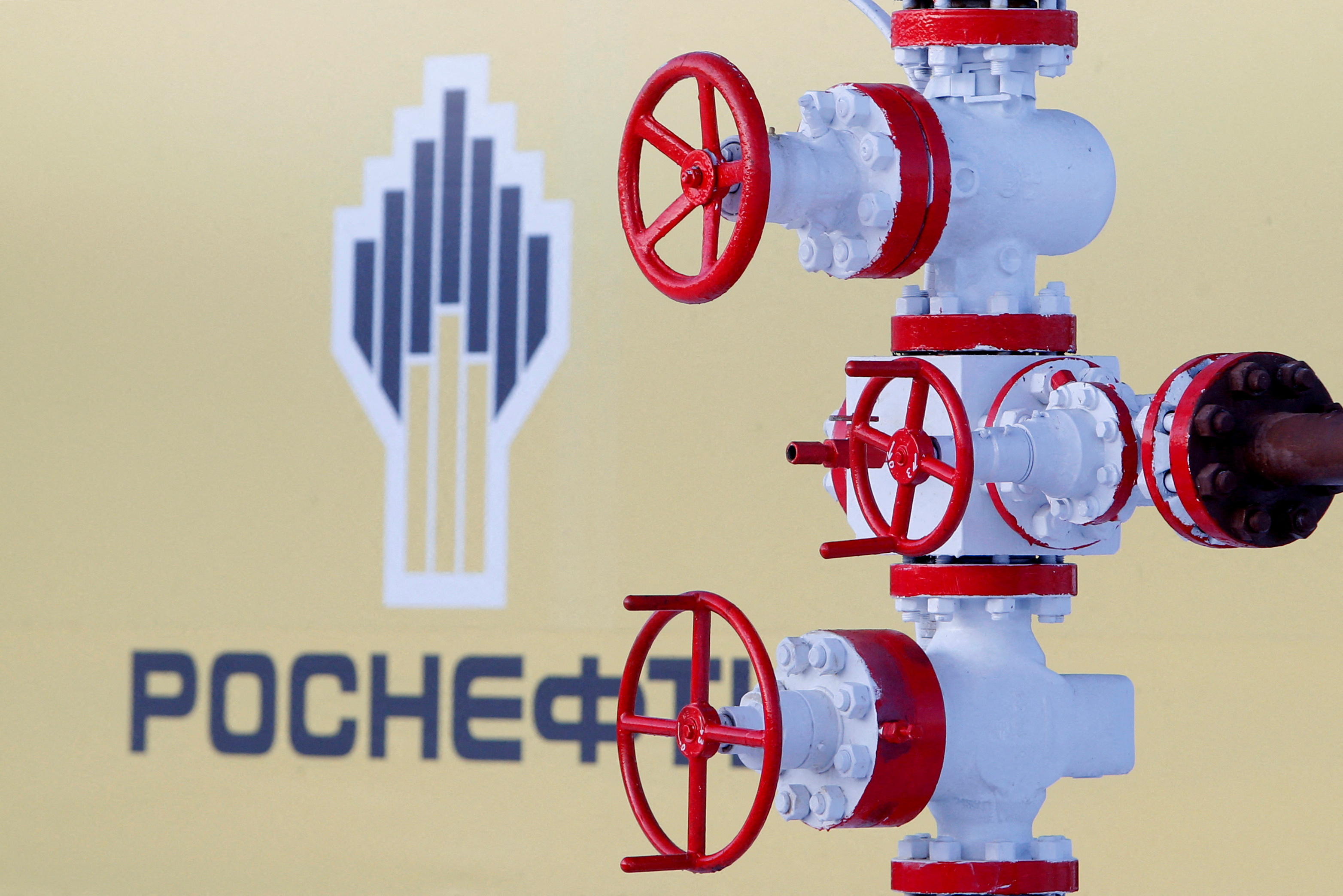 Logo of Russian state oil company Rosneft is pictured behind pipe at Samotlor oil field outside the West Siberian city of Nizhnevartovsk