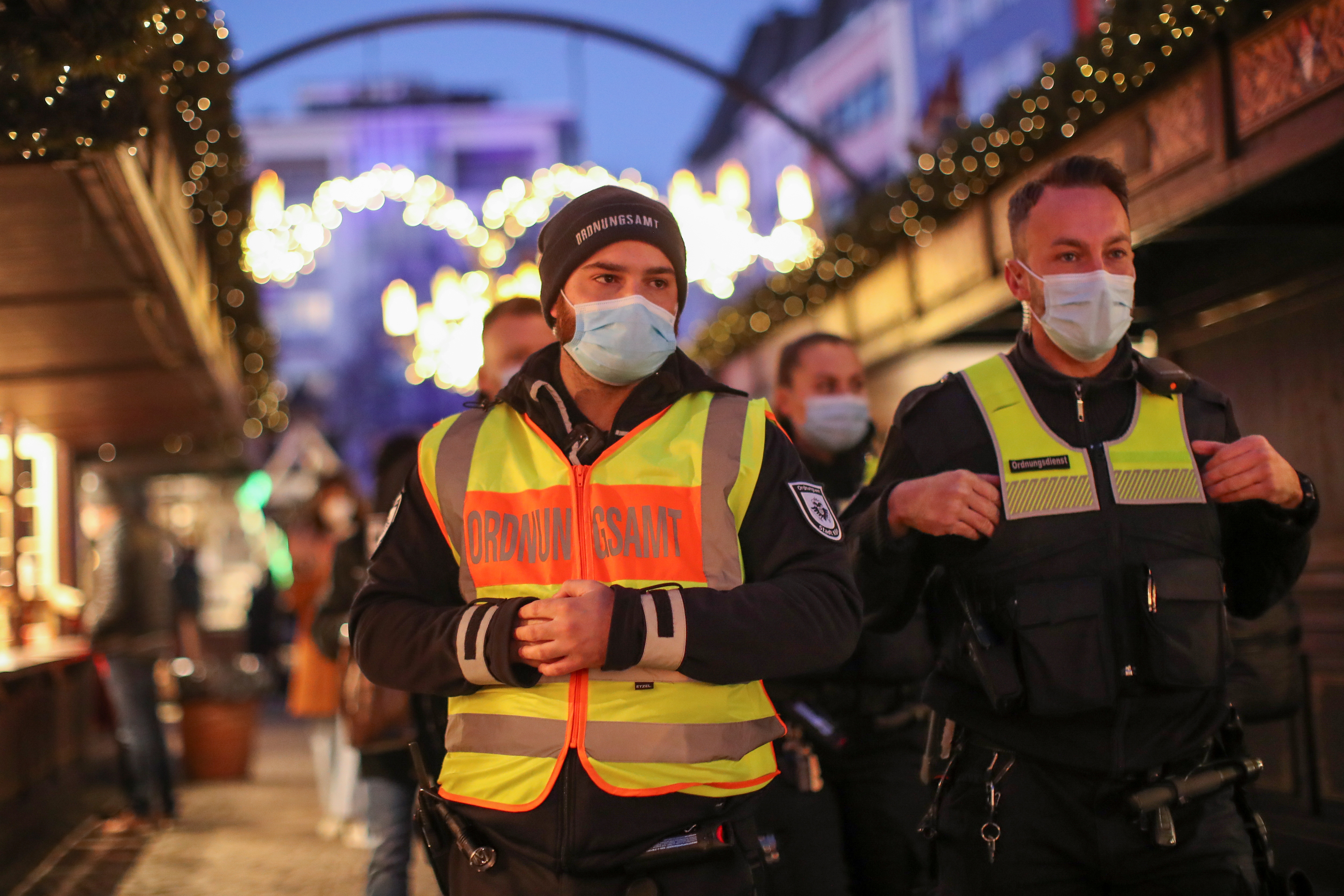 Medlemmar av byrån för allmän ordning går på en julmarknad, där de kontrollerar "2G"-regeln som tillåter endast de som vaccinerats eller tillfrisknat från coronaviruset (COVID-19) att besöka, i Köln, Tyskland, den 22 november 2021. REUTERS /Thilo Schmuelgen