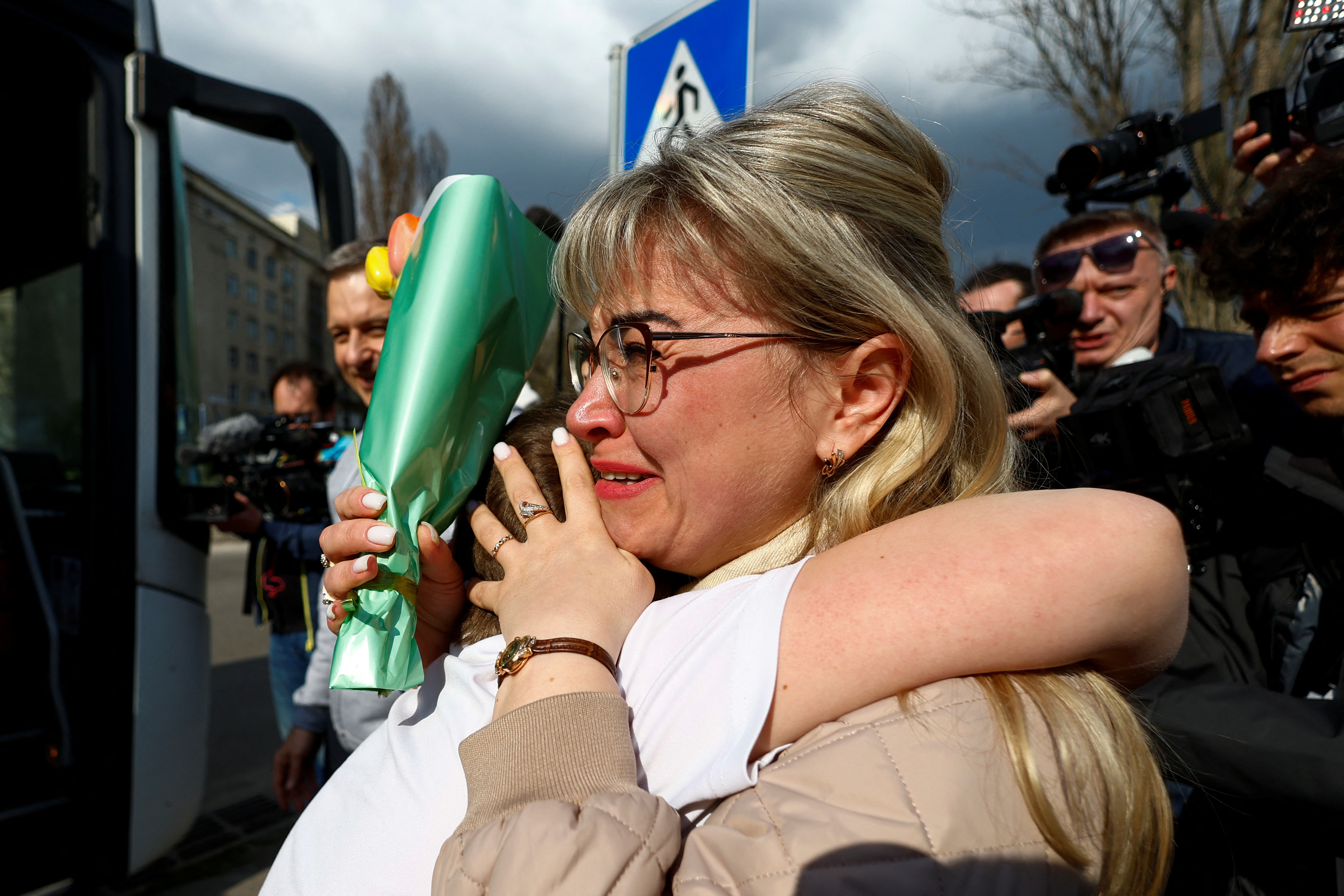 Yana Shapochko reacts as she embraces her 9-year-old nephew Danyil, who was taken to Russia, after he returned via the Ukraine-Belarus border, in Kyiv