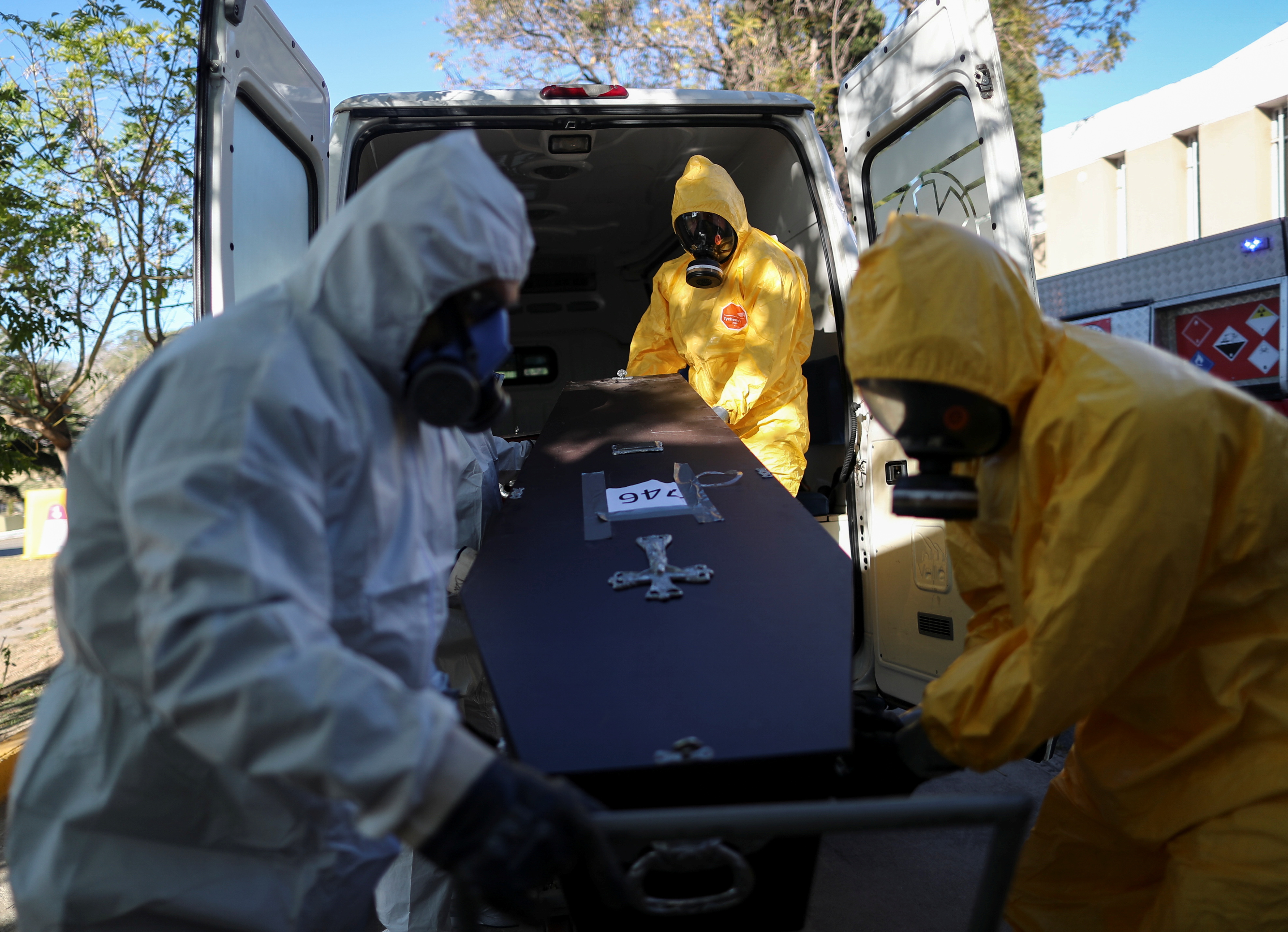 Members of the Department of High Risk Units (DUAR) unload a coffin of a person who died from the coronavirus disease (COVID-19) from an ambulance at the San Vicente cemetery, in Cordoba, Argentina, July 10, 2021. REUTERS/Agustin Marcarian