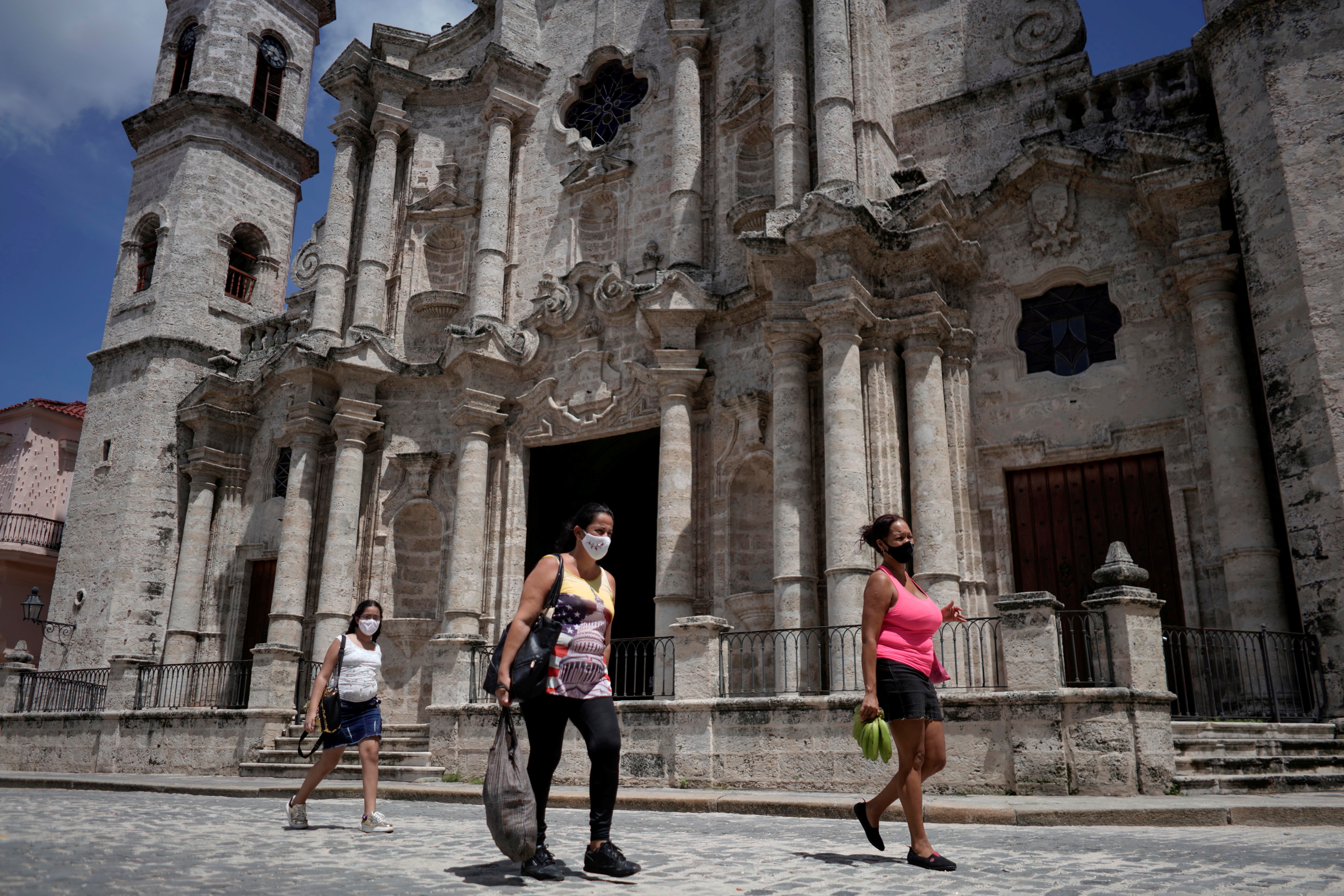 People pass by in front of the Havana's Cathedral