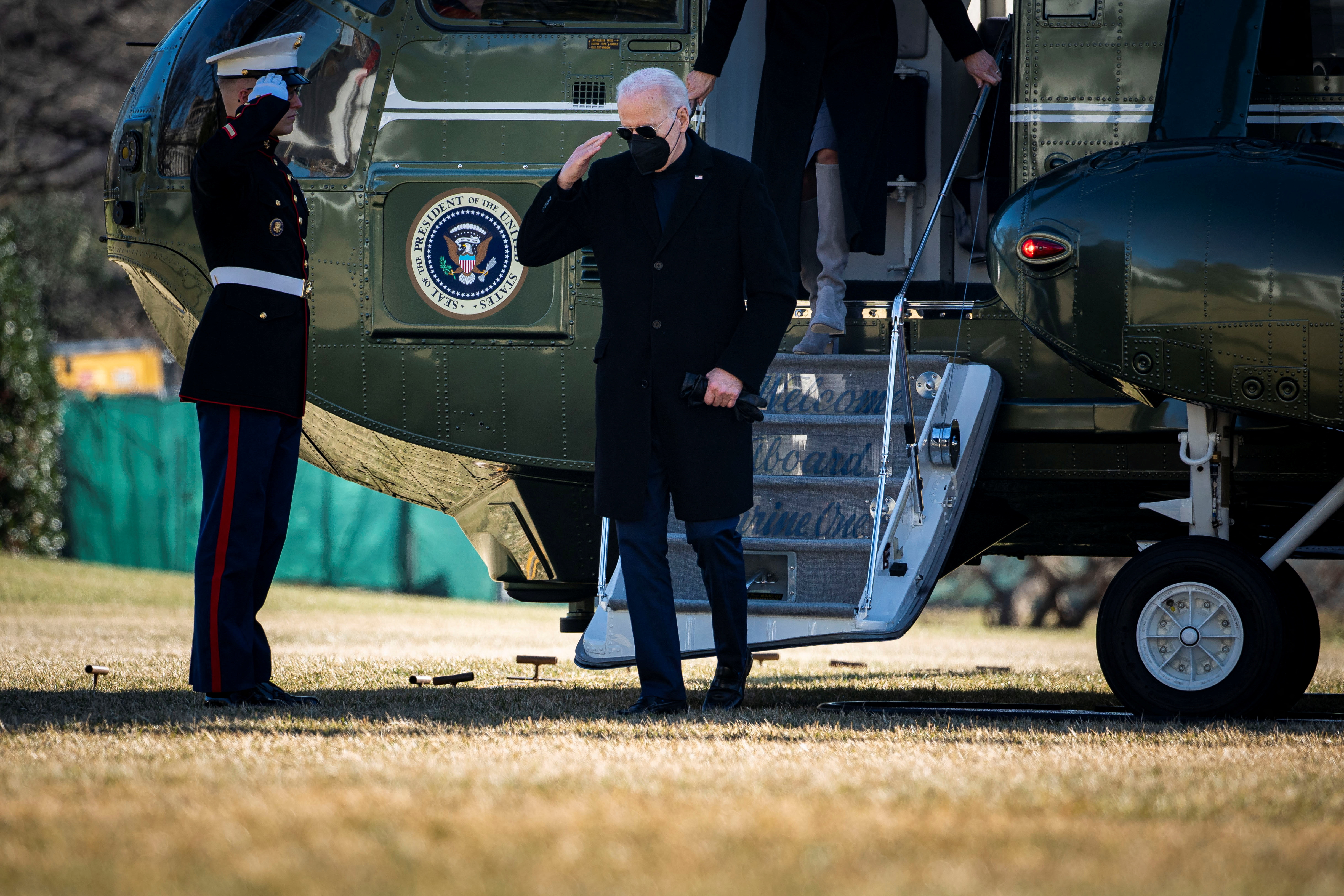 U.S. President Joe Biden salutes as he arrives on Marine One on the South Lawn of the White House in Washington
