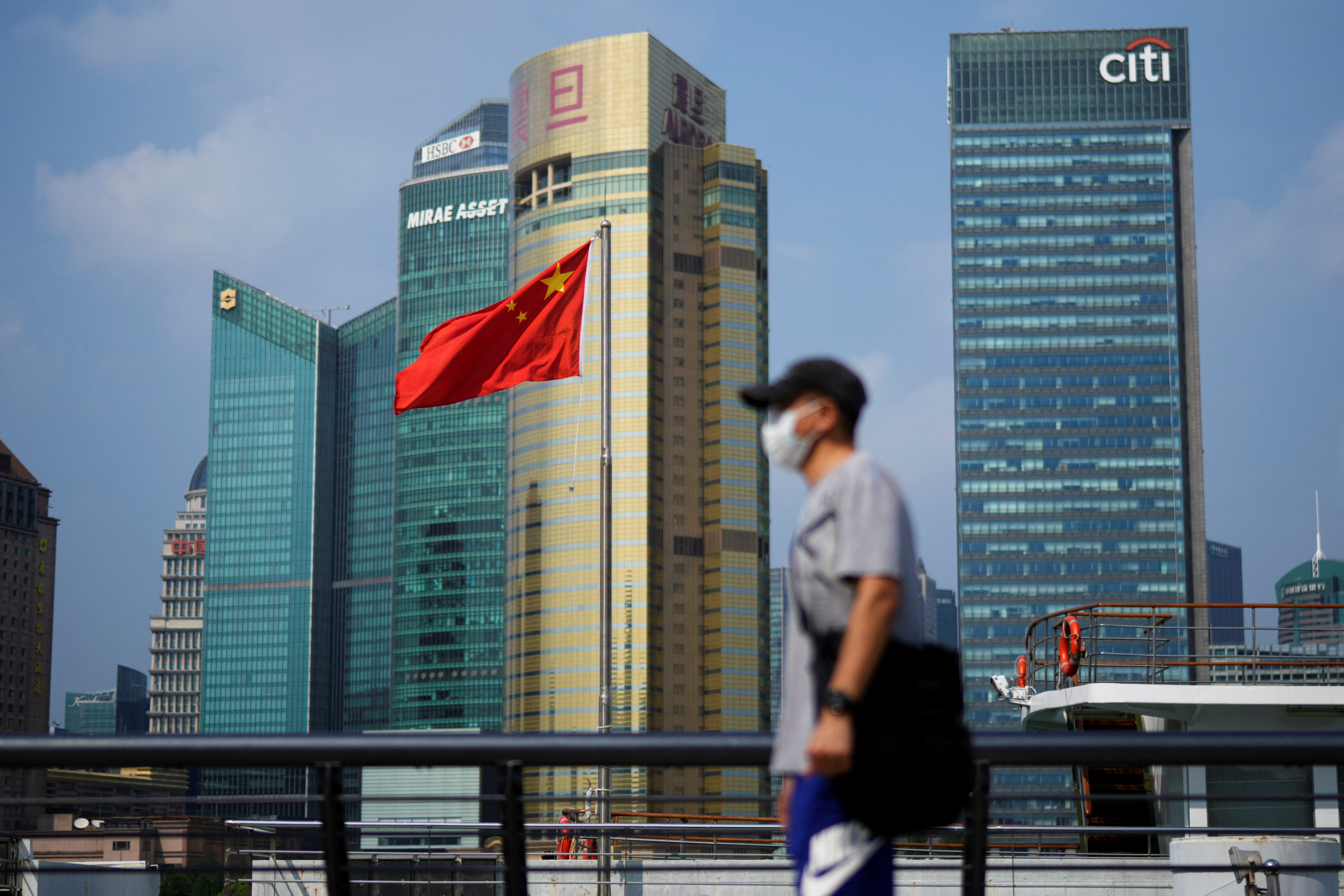 Man walks past a Chinese flag in Shanghai