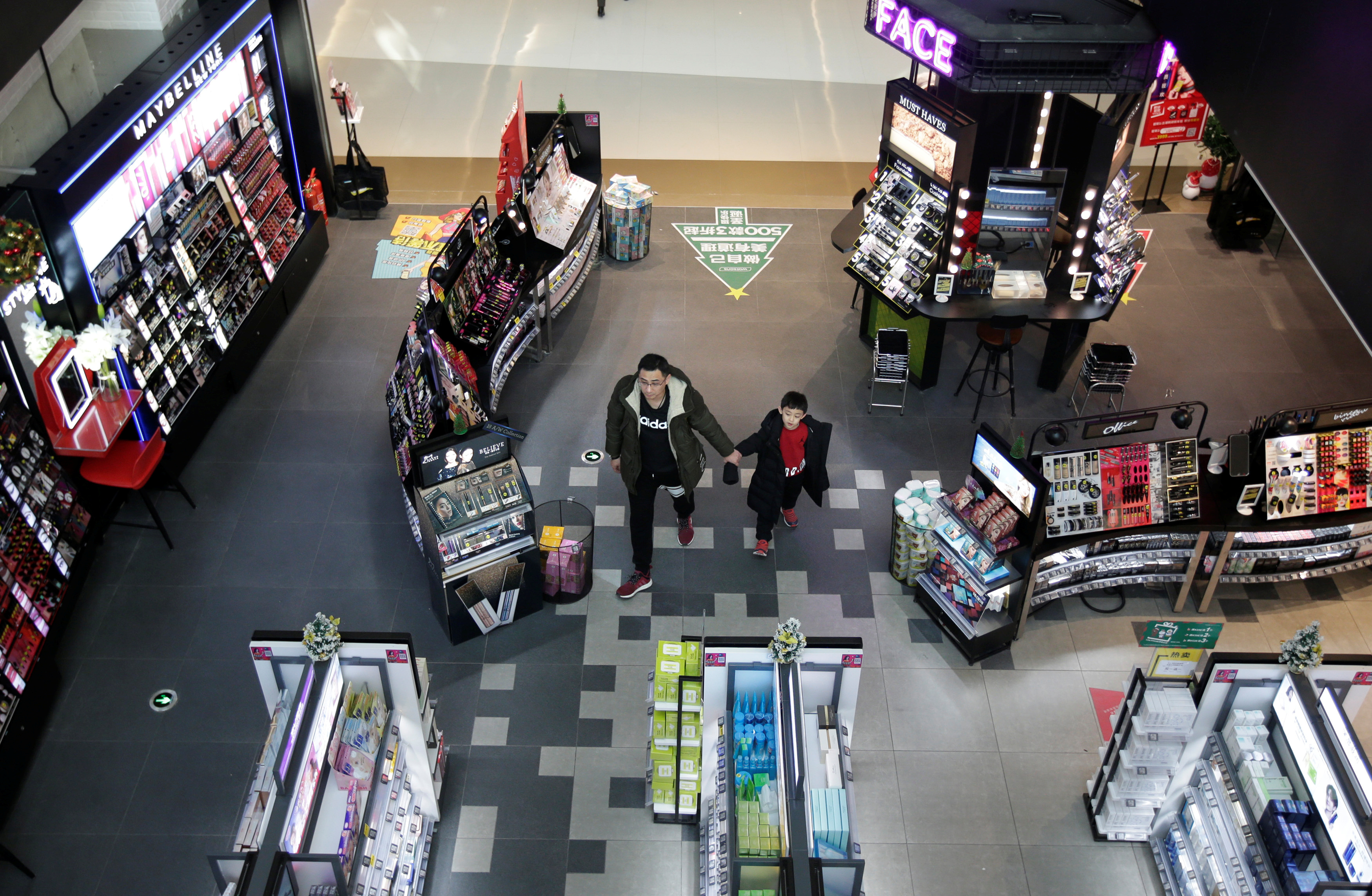 A man and a boy walk at a shopping center in Beijing