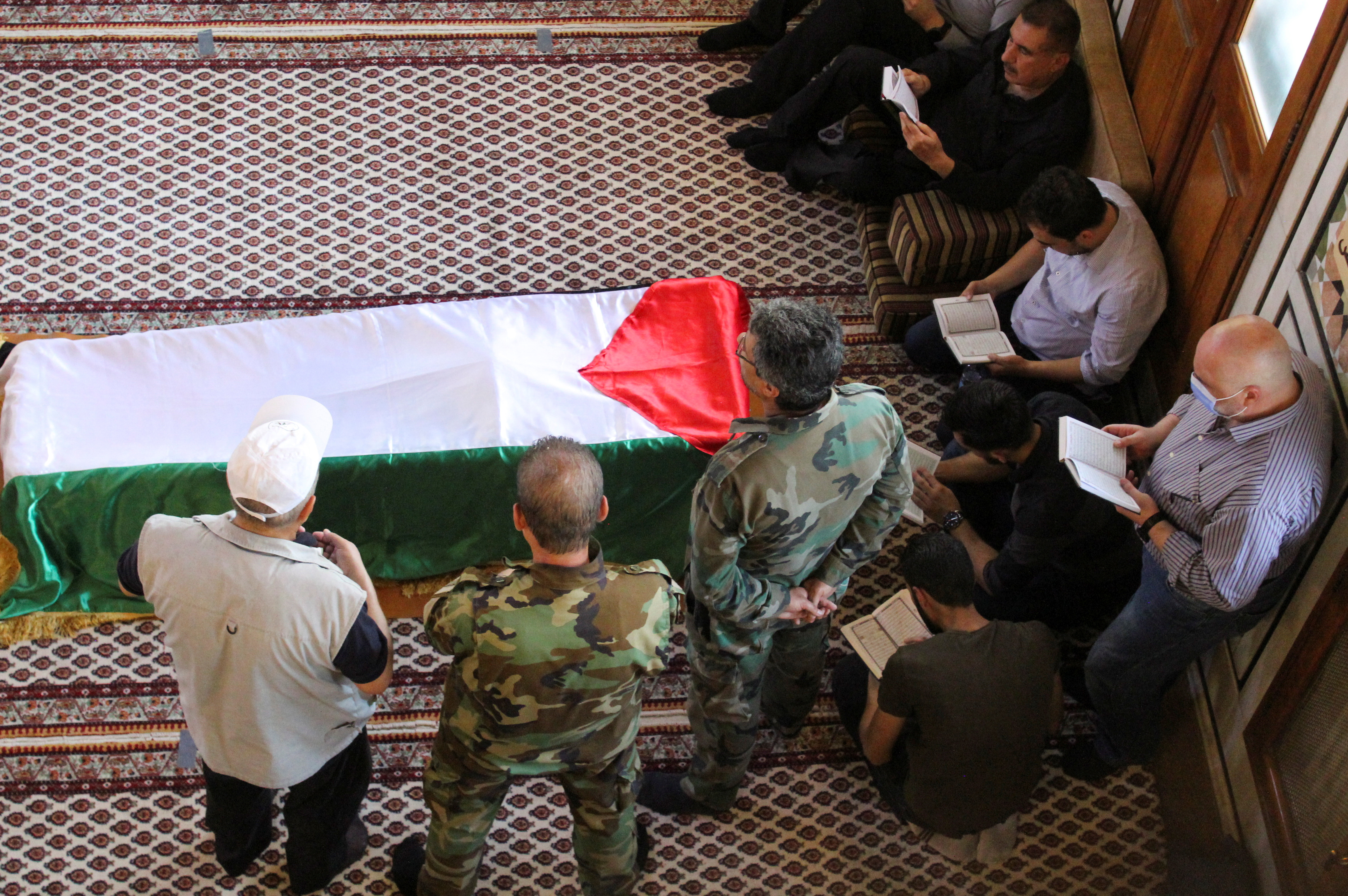 Mourners stand near the coffin of Ahmed Jibril, founder of pro-Syrian Palestinian guerrilla faction during his funeral at a mosque in Damascus